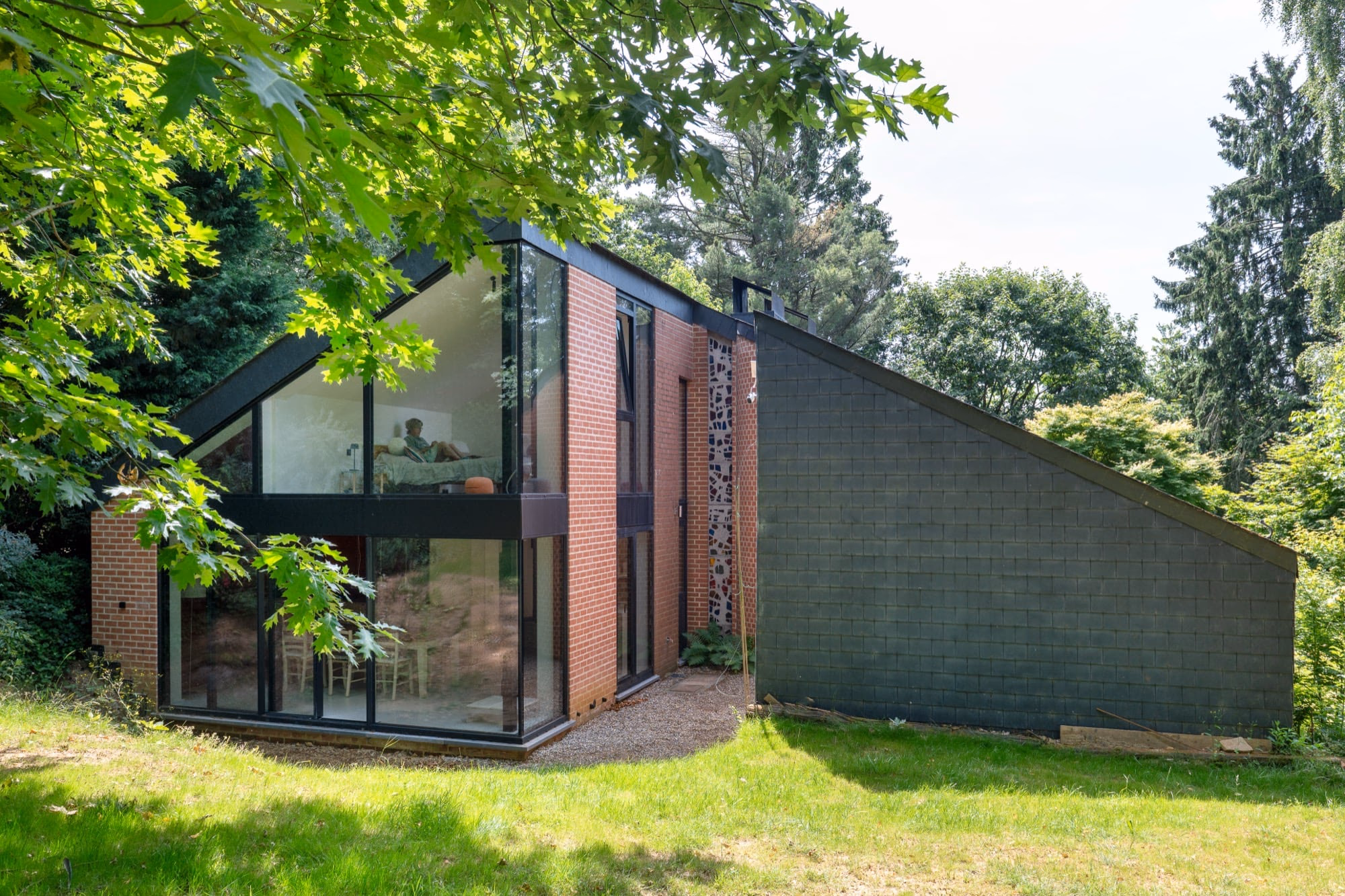 A brick house with a black roof and many windows