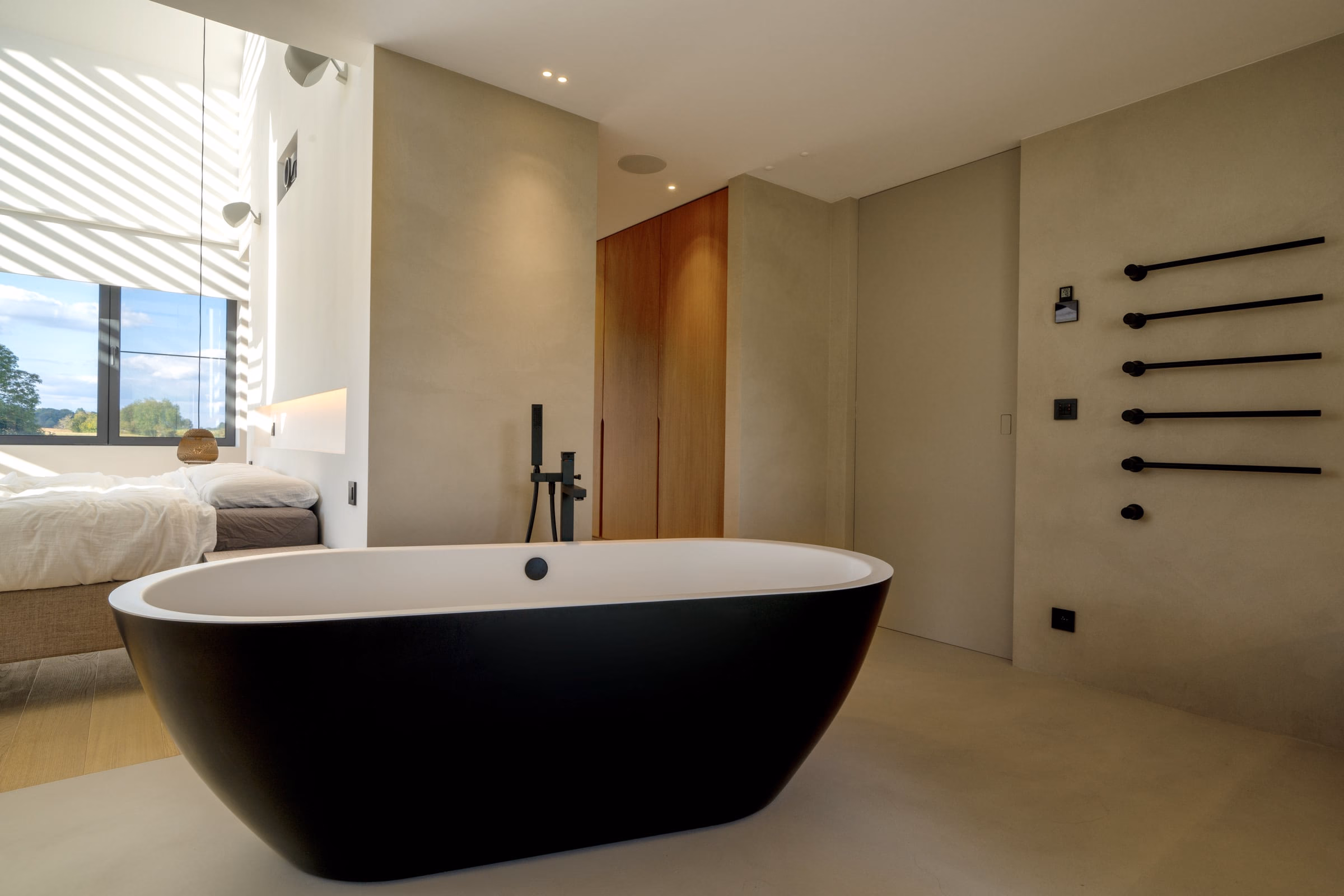 A bathroom with a black bathtub and a wooden door