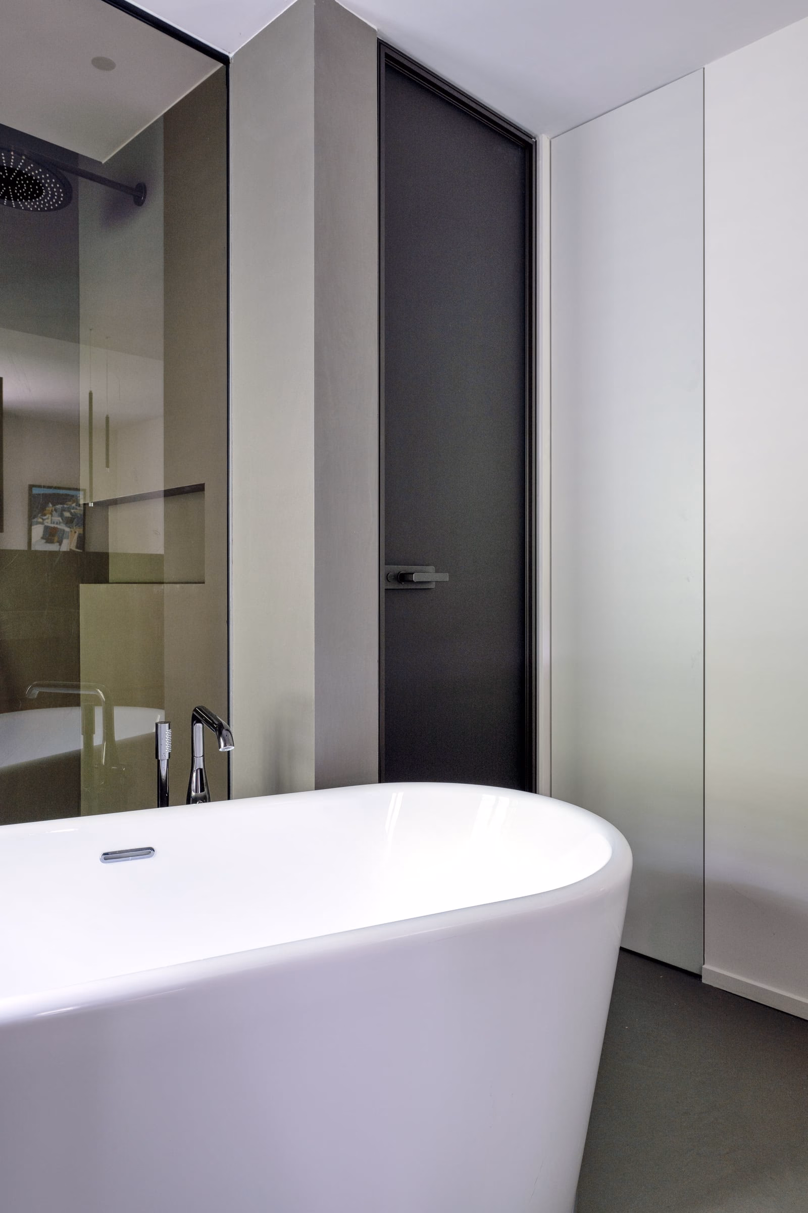 A bathroom with a bathtub and a black door