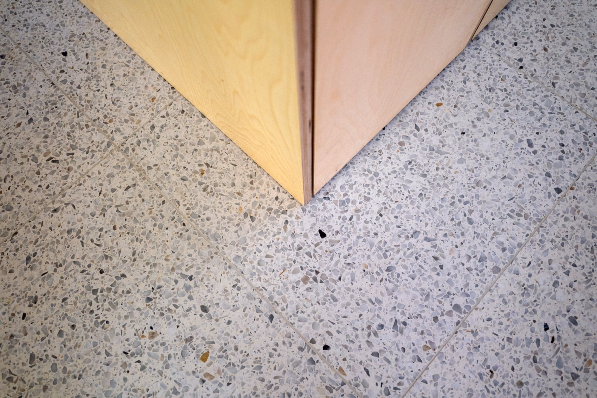 A corner of a room with a white tiled floor