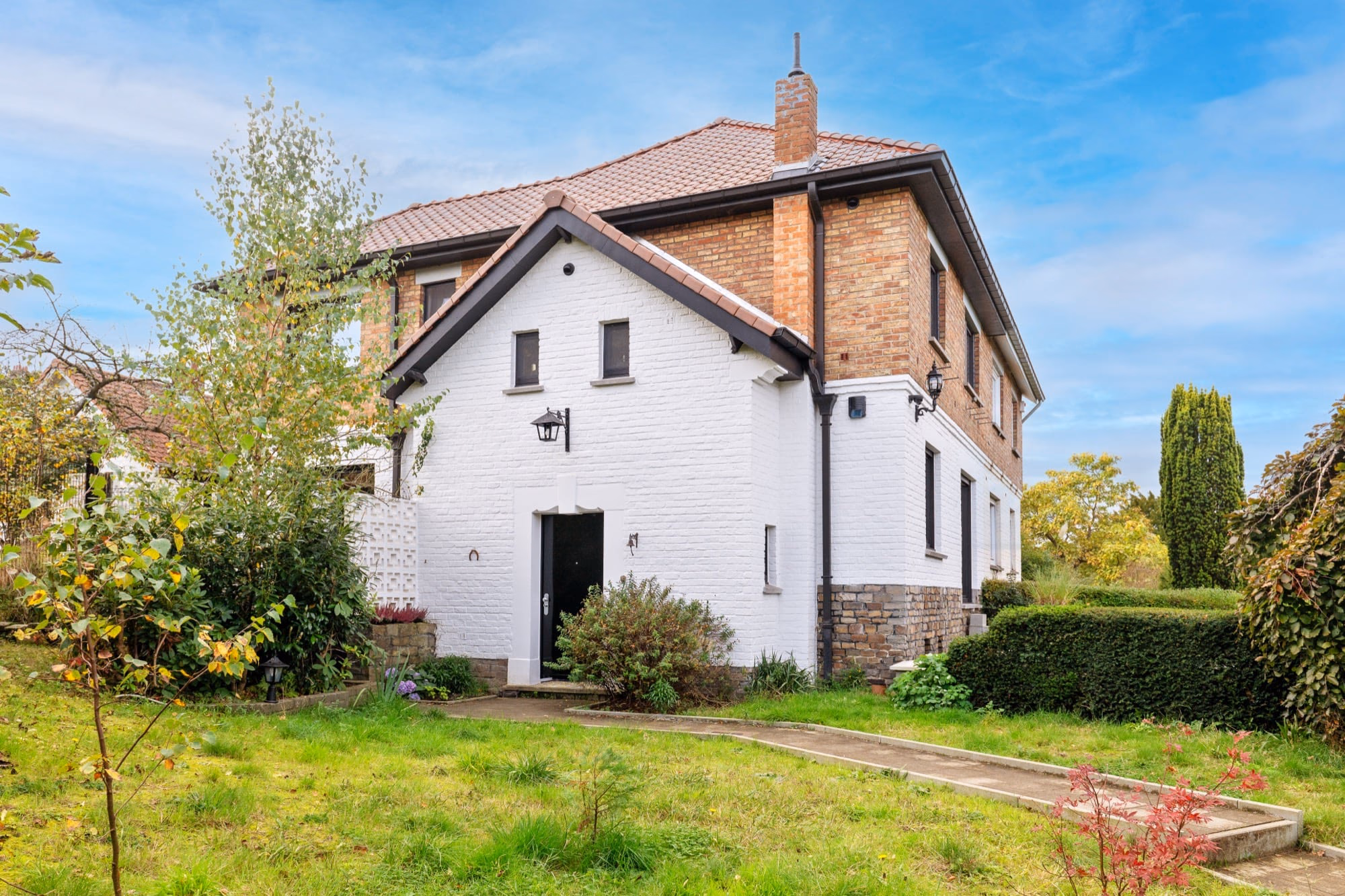 A white house with a tiled roof and a chimney