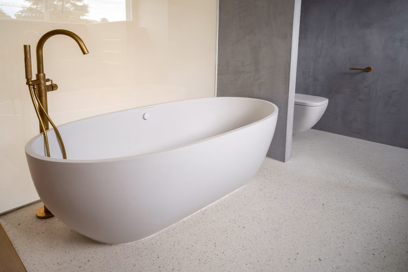 A white bathtub beside a toilet