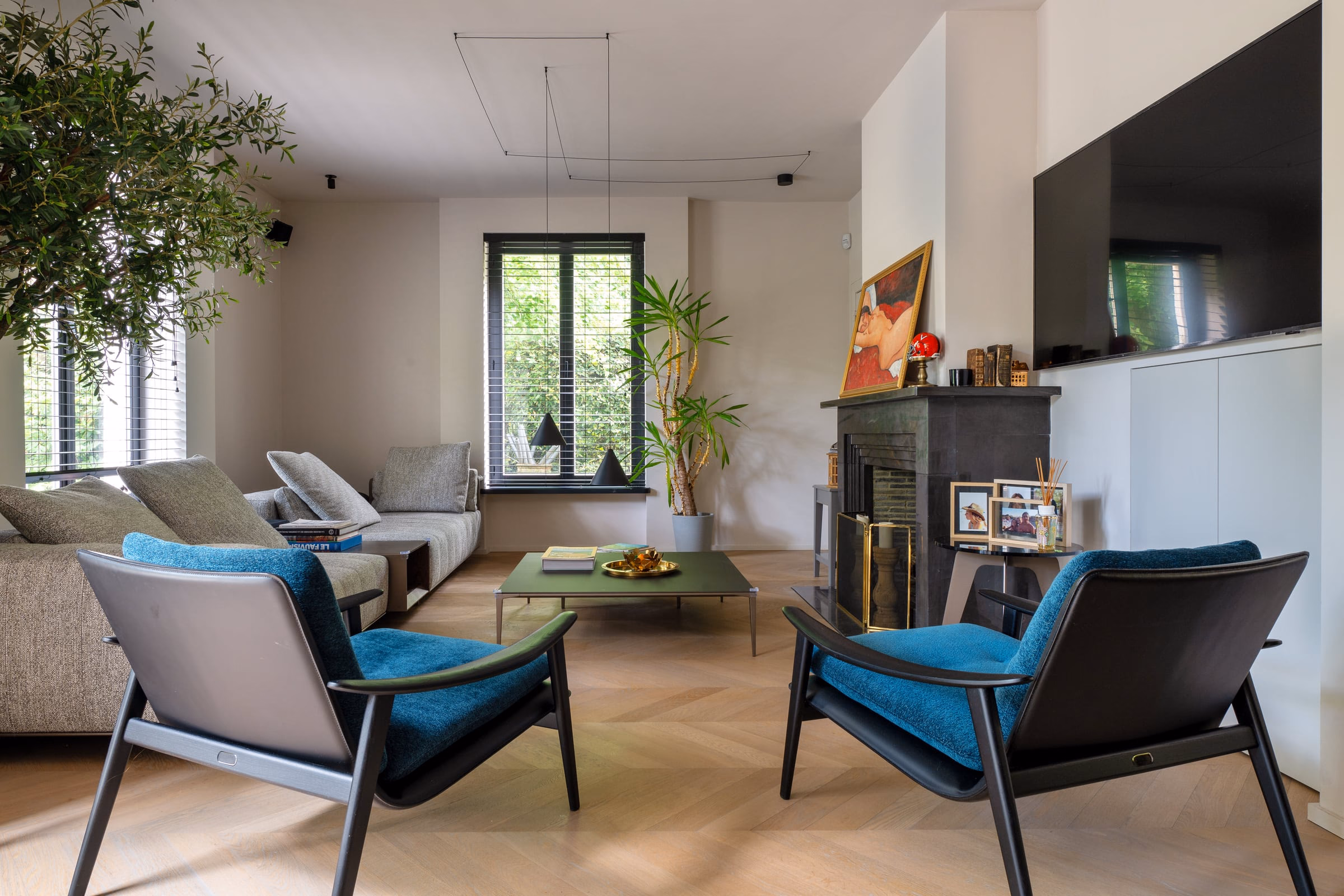 A living room with two blue armchairs and a green coffee table