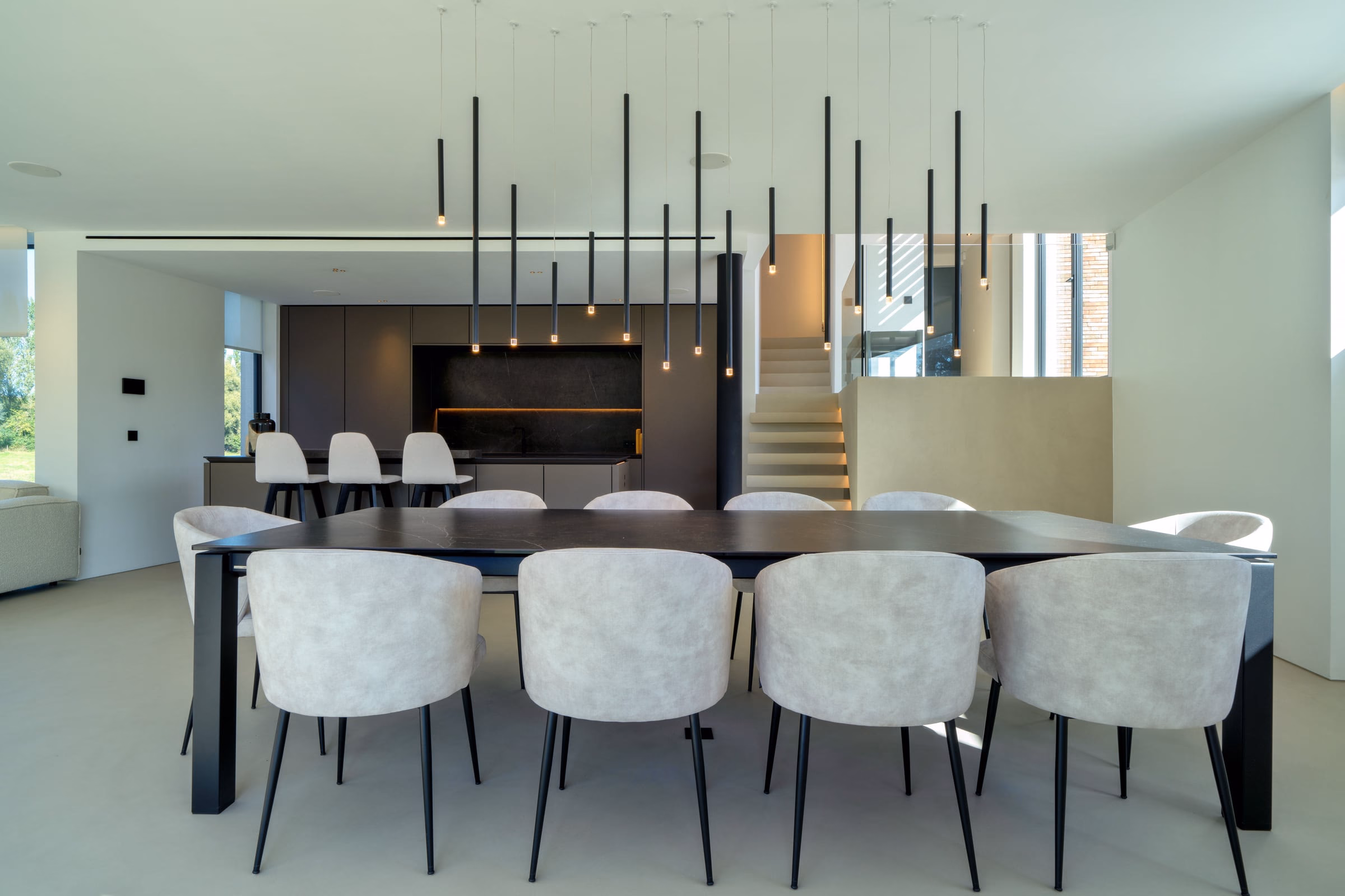 A dining room with a black table and white chairs