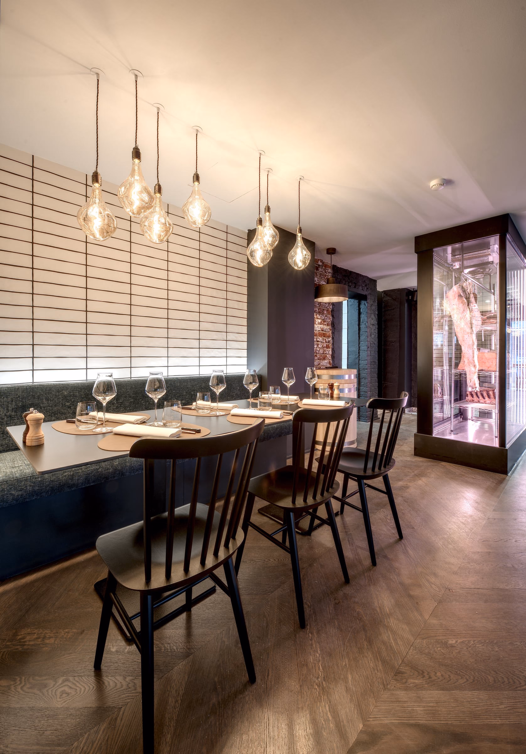 A dining room with tables, chairs and a meat display