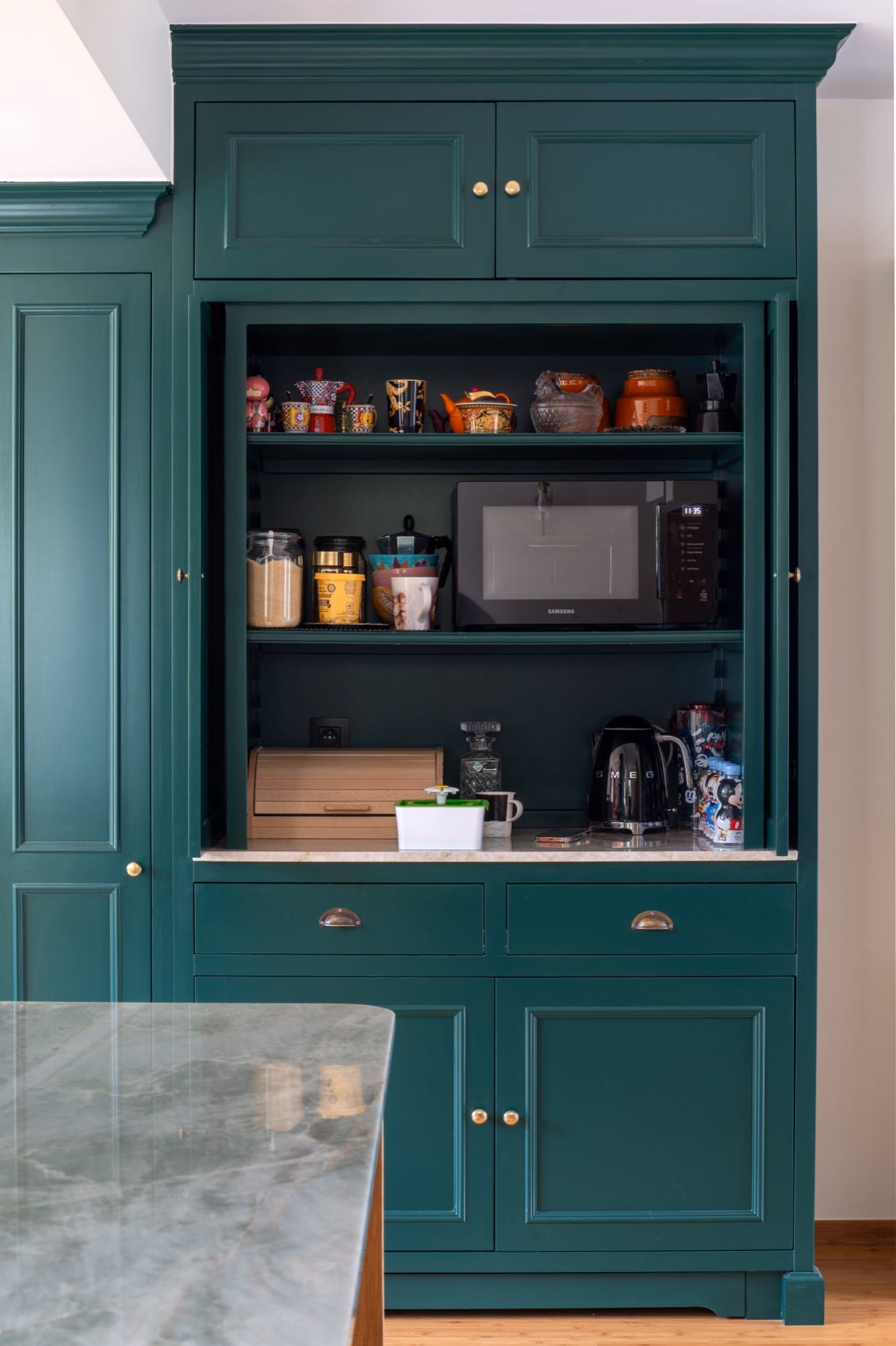 A microwave on a shelf in a kitchen