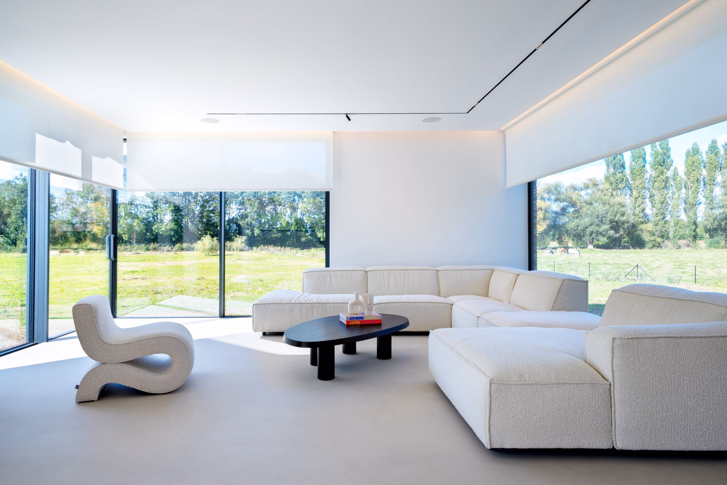 A living room with a white corner sofa and a black coffee table
