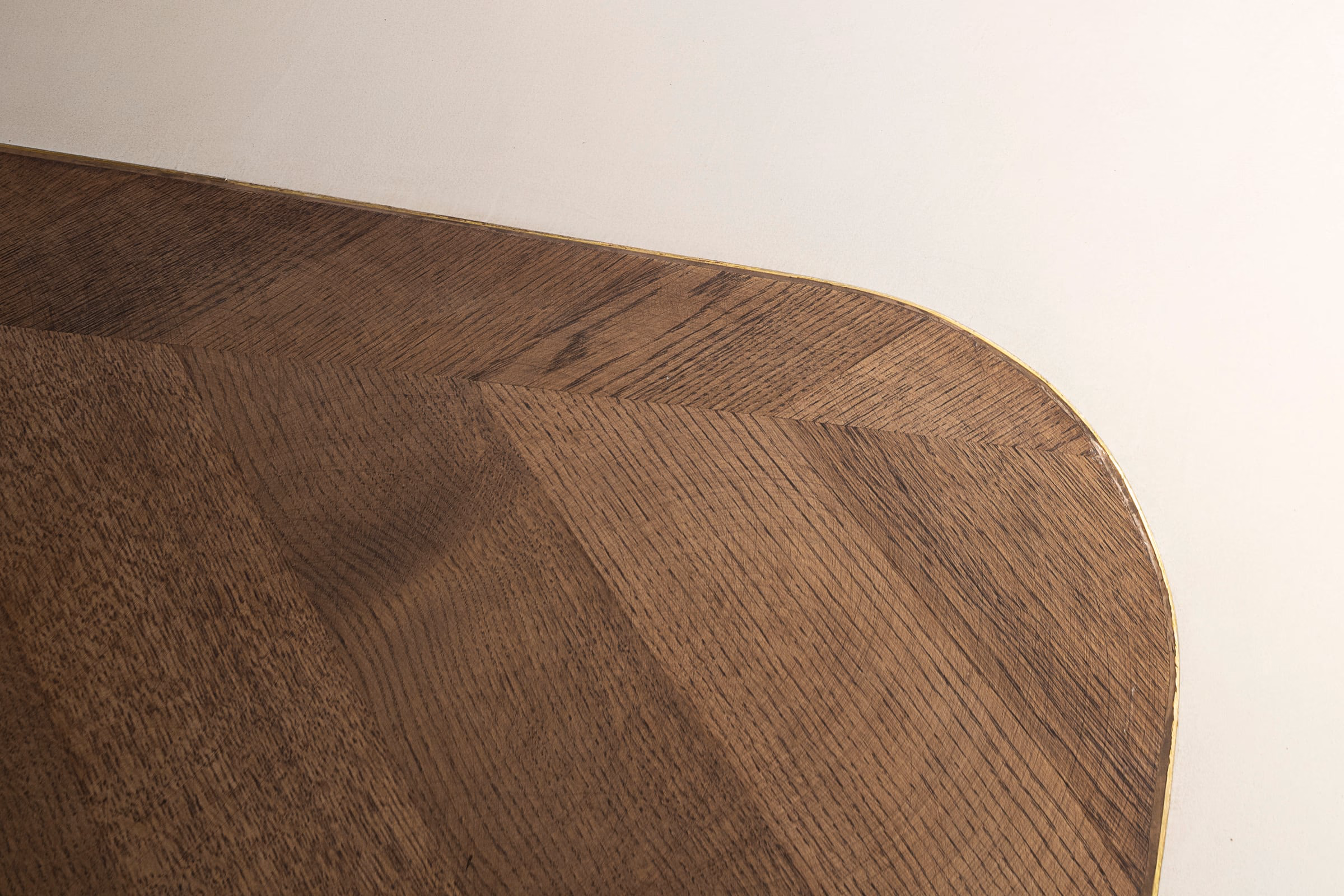 Detail of a wooden table with brass trim