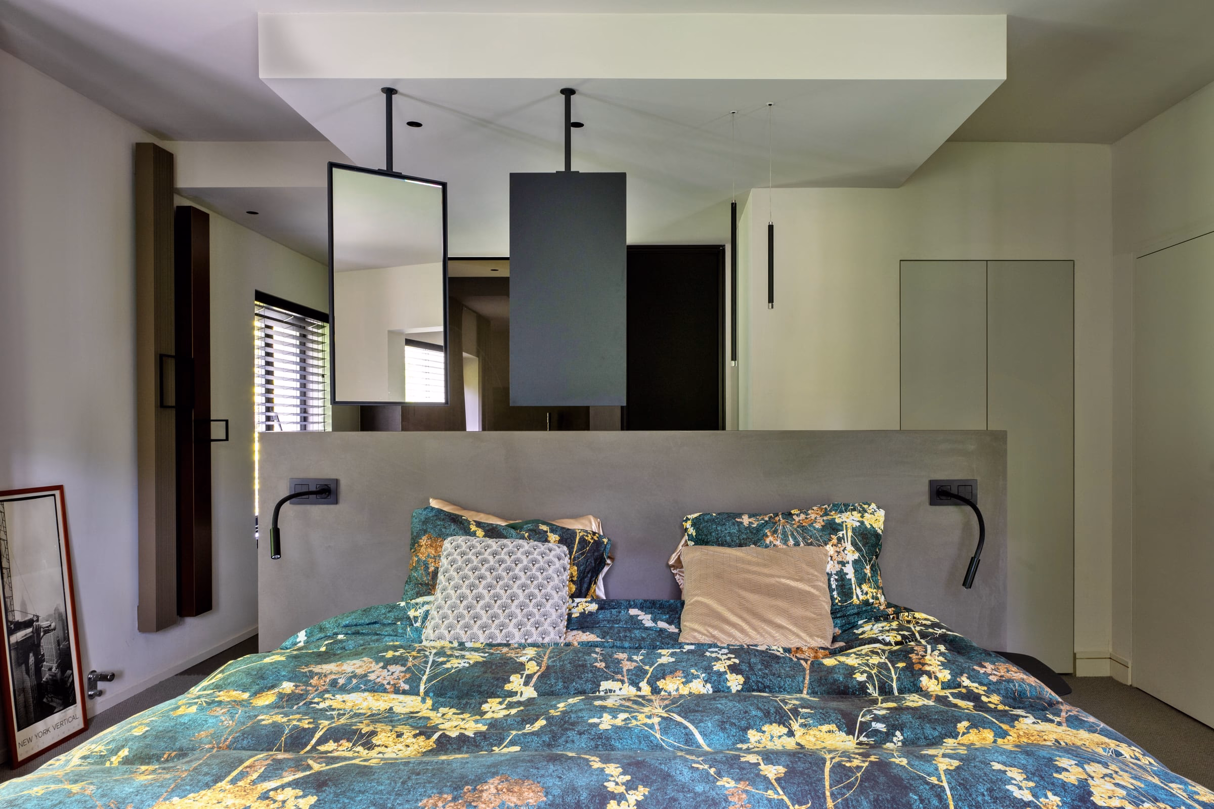 A bed with a floral bedspread and cushions