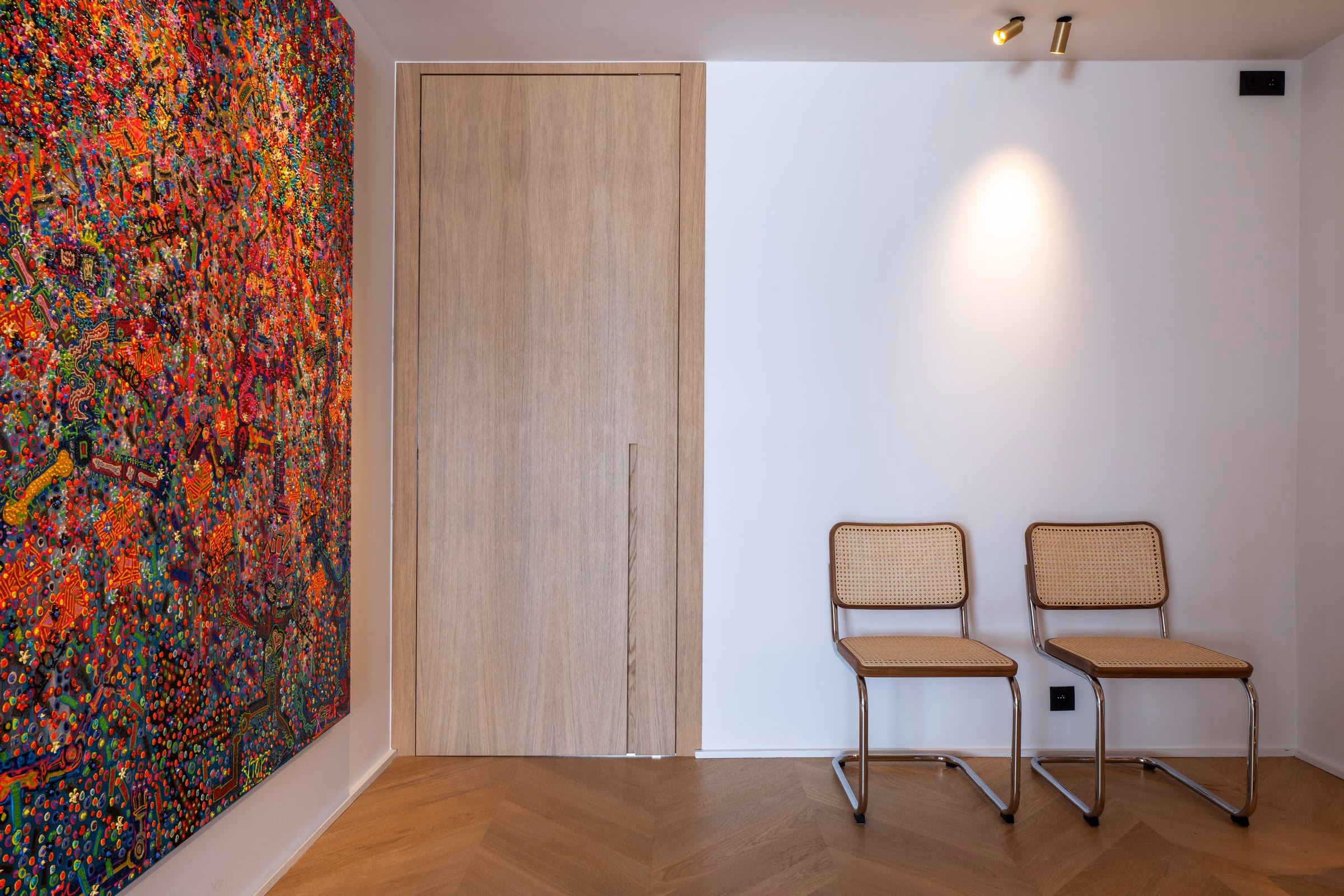 A room with two chairs and a painting on the wall