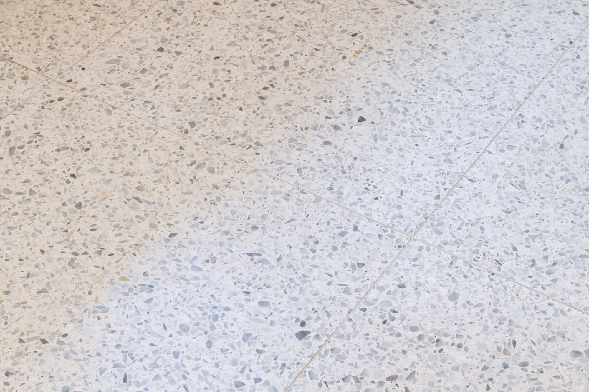 A white tiled floor scattered with small pebbles