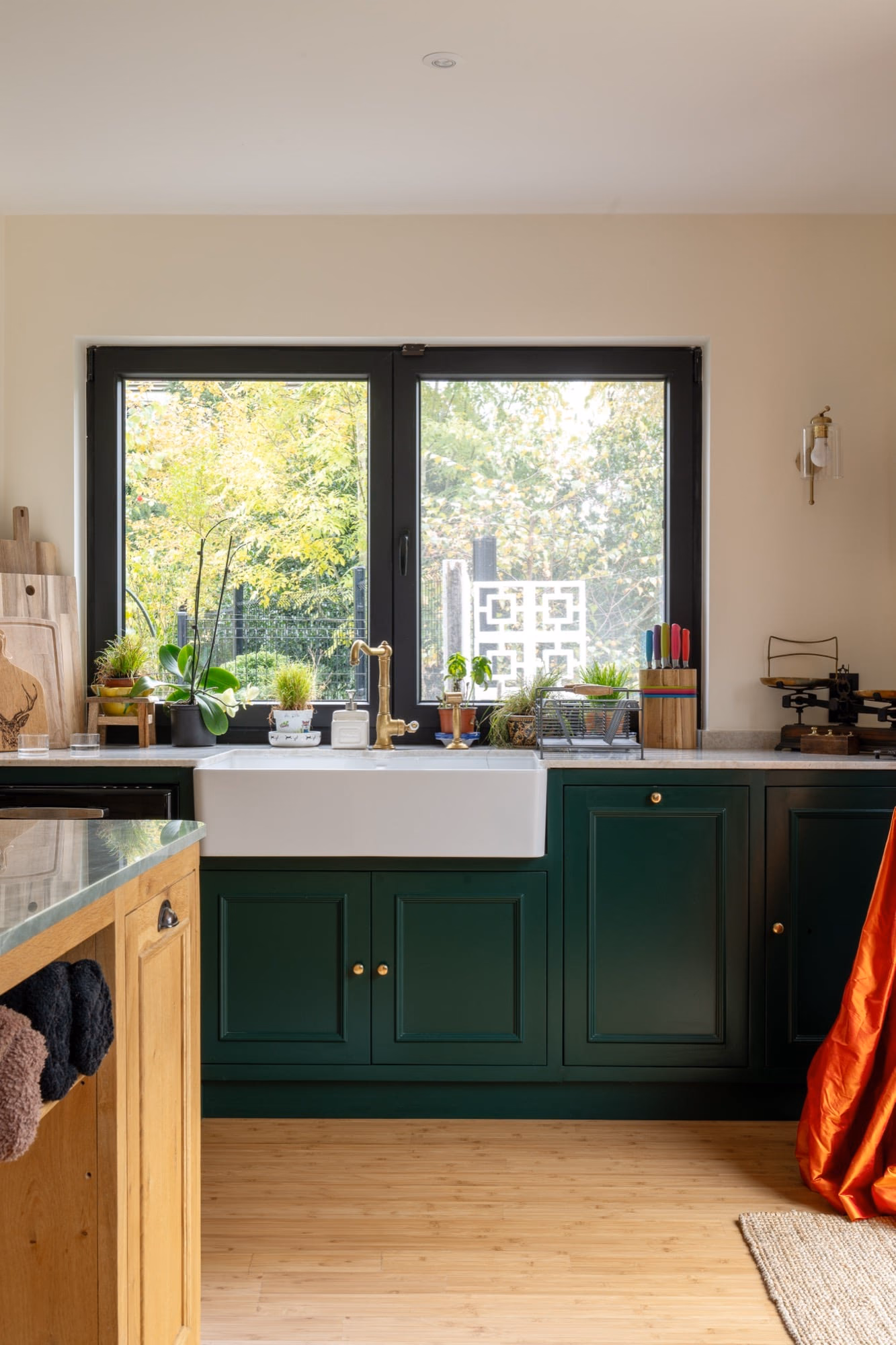 A kitchen with green cabinets and a white sink