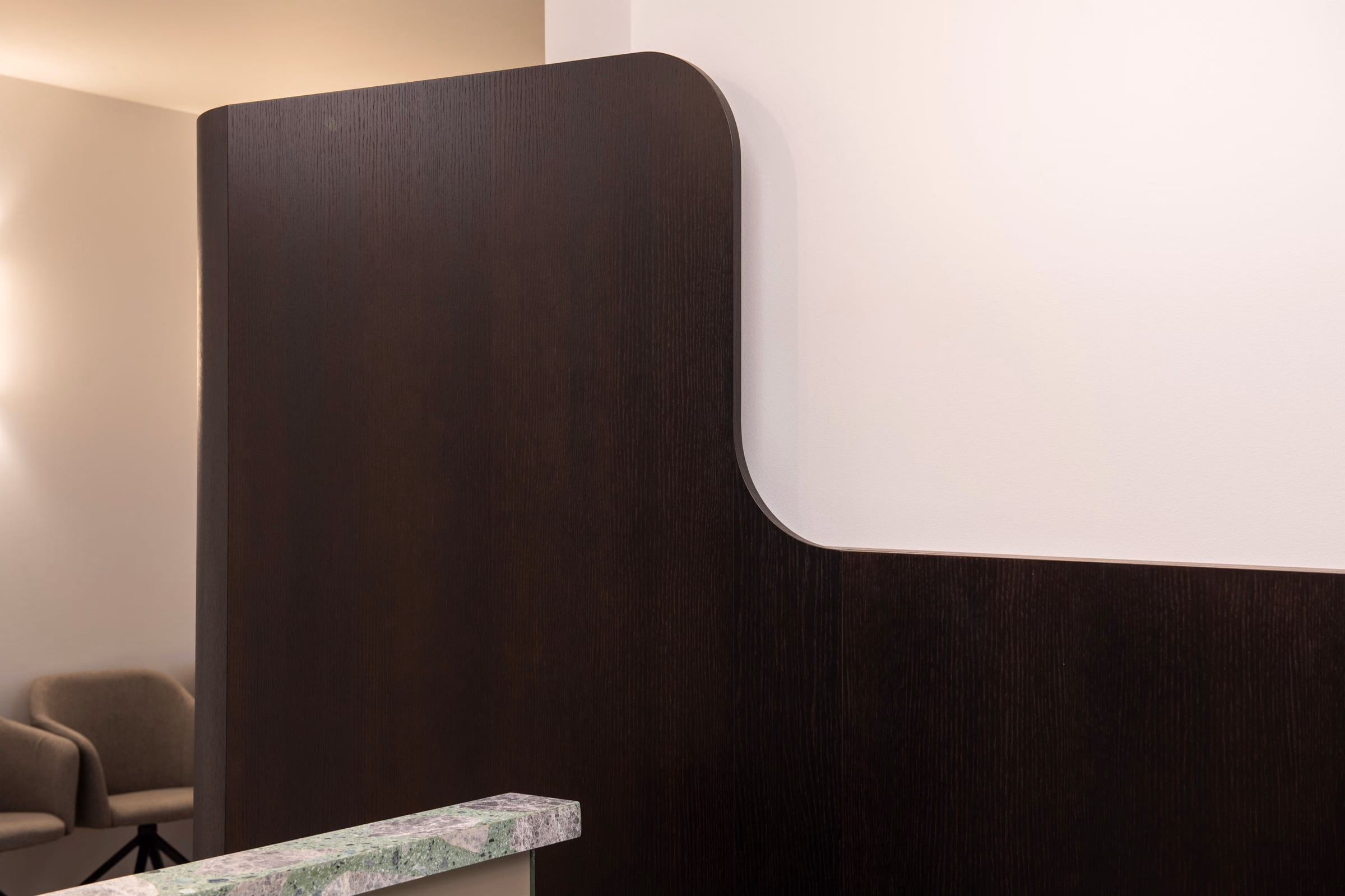 A dark wooden wall with a green marble counter