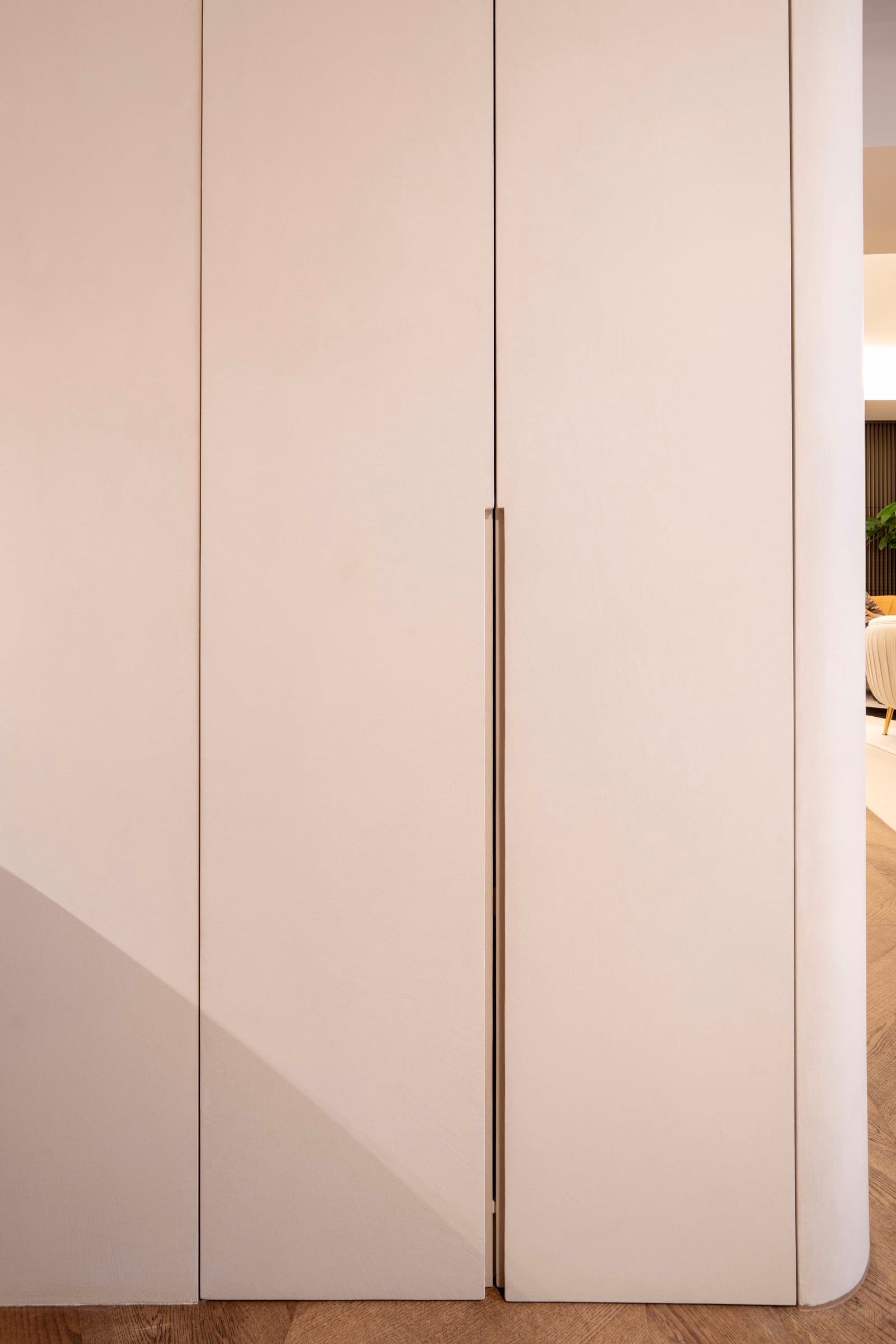 A white cabinet with a stainless steel handle