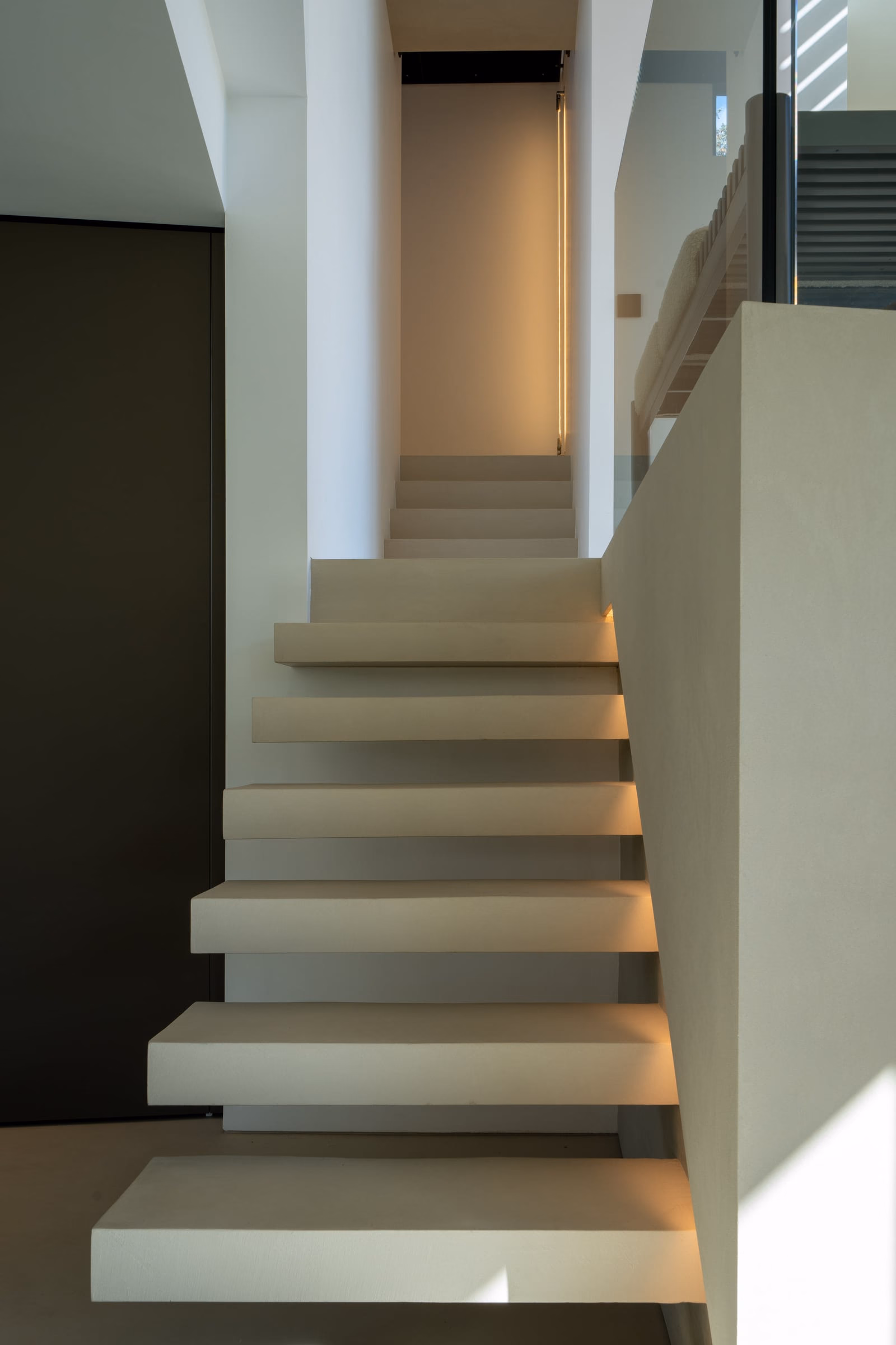 A staircase with a light at the bottom step