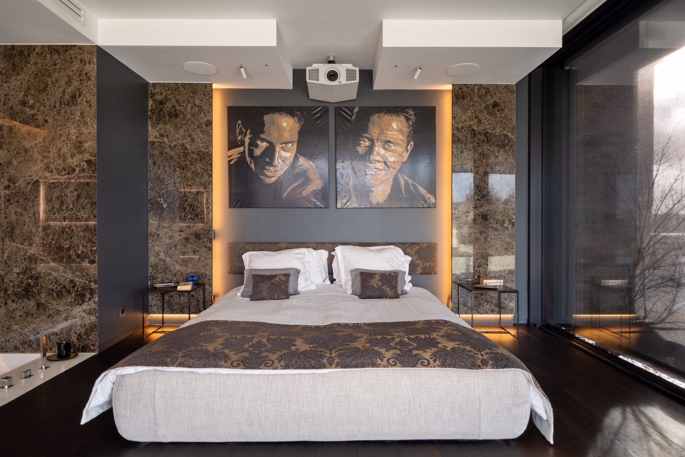 A bedroom with two paintings above the bed