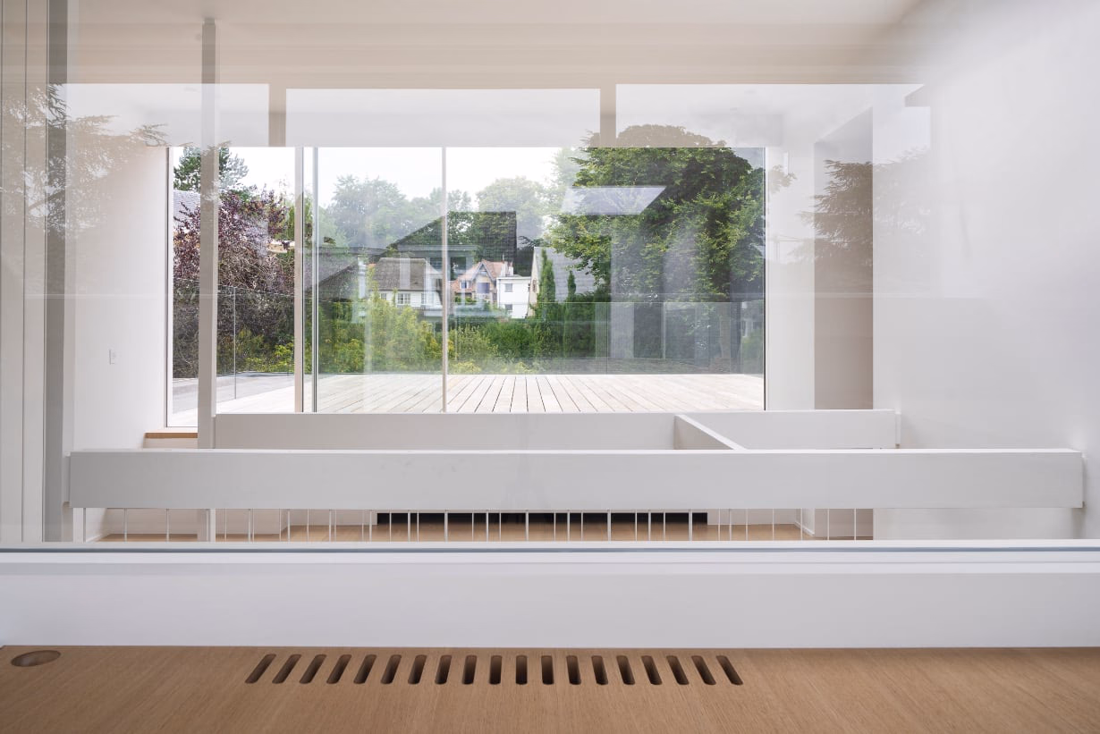 A large window looking out on a house and trees