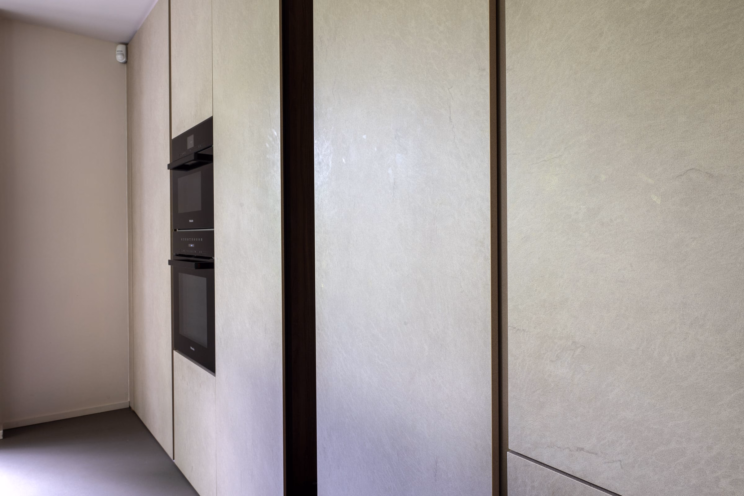 A kitchen with white cabinets and black appliances