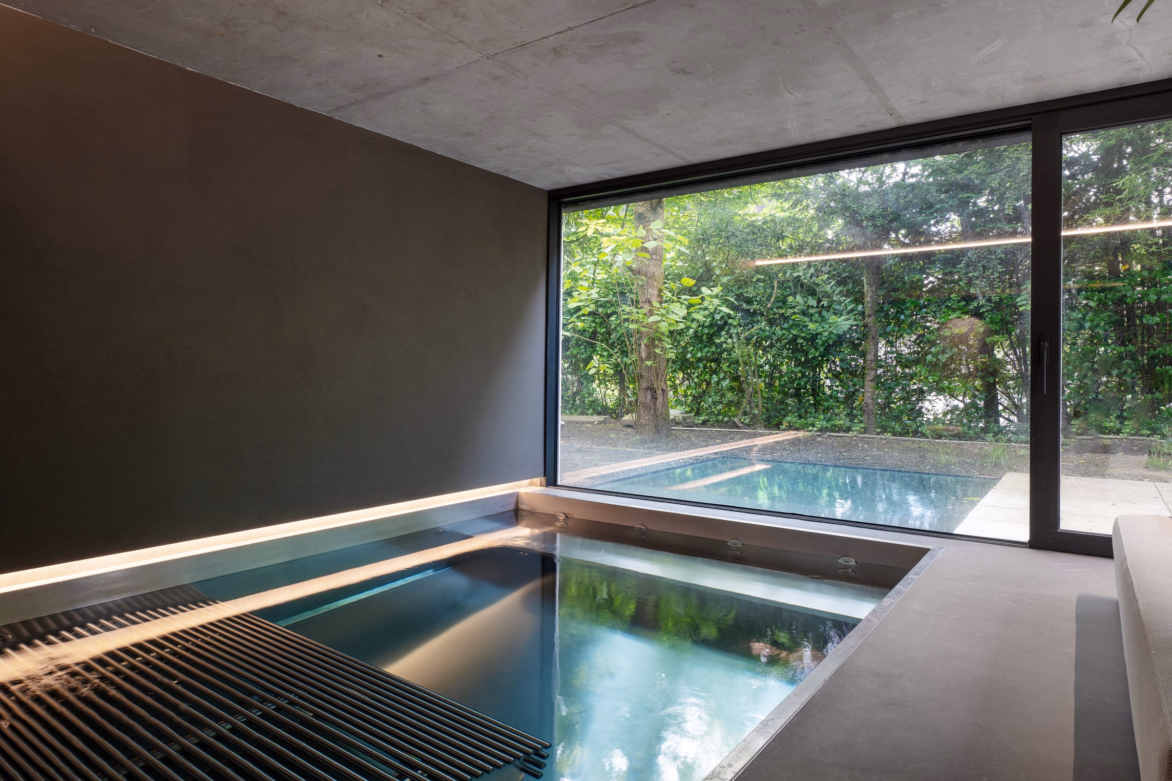 A large window overlooking a swimming pool and trees