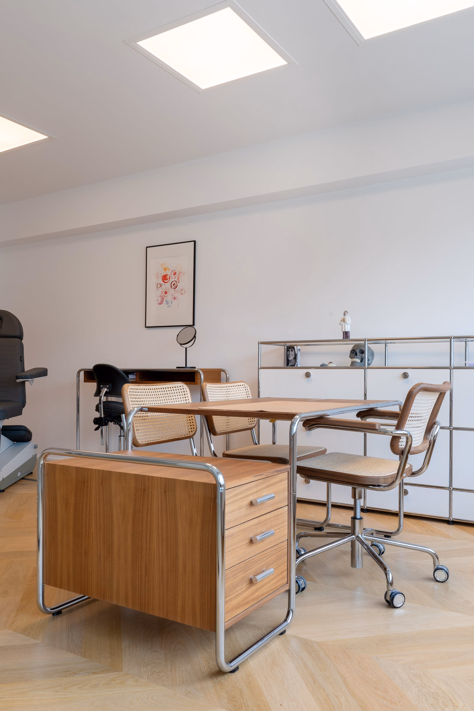 A room with a table, chairs and a painting on the wall