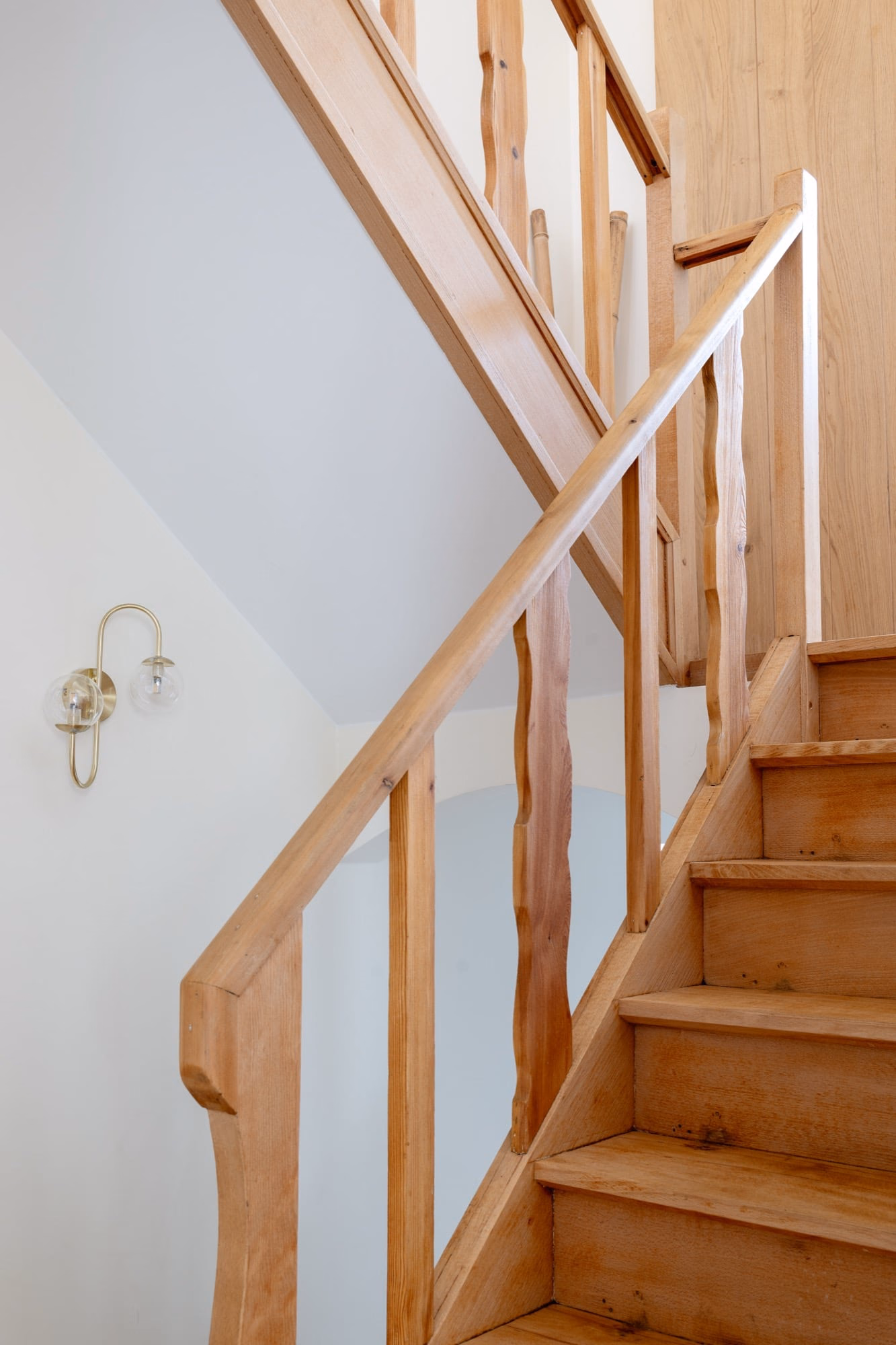 A wooden staircase with a clear glass balustrade