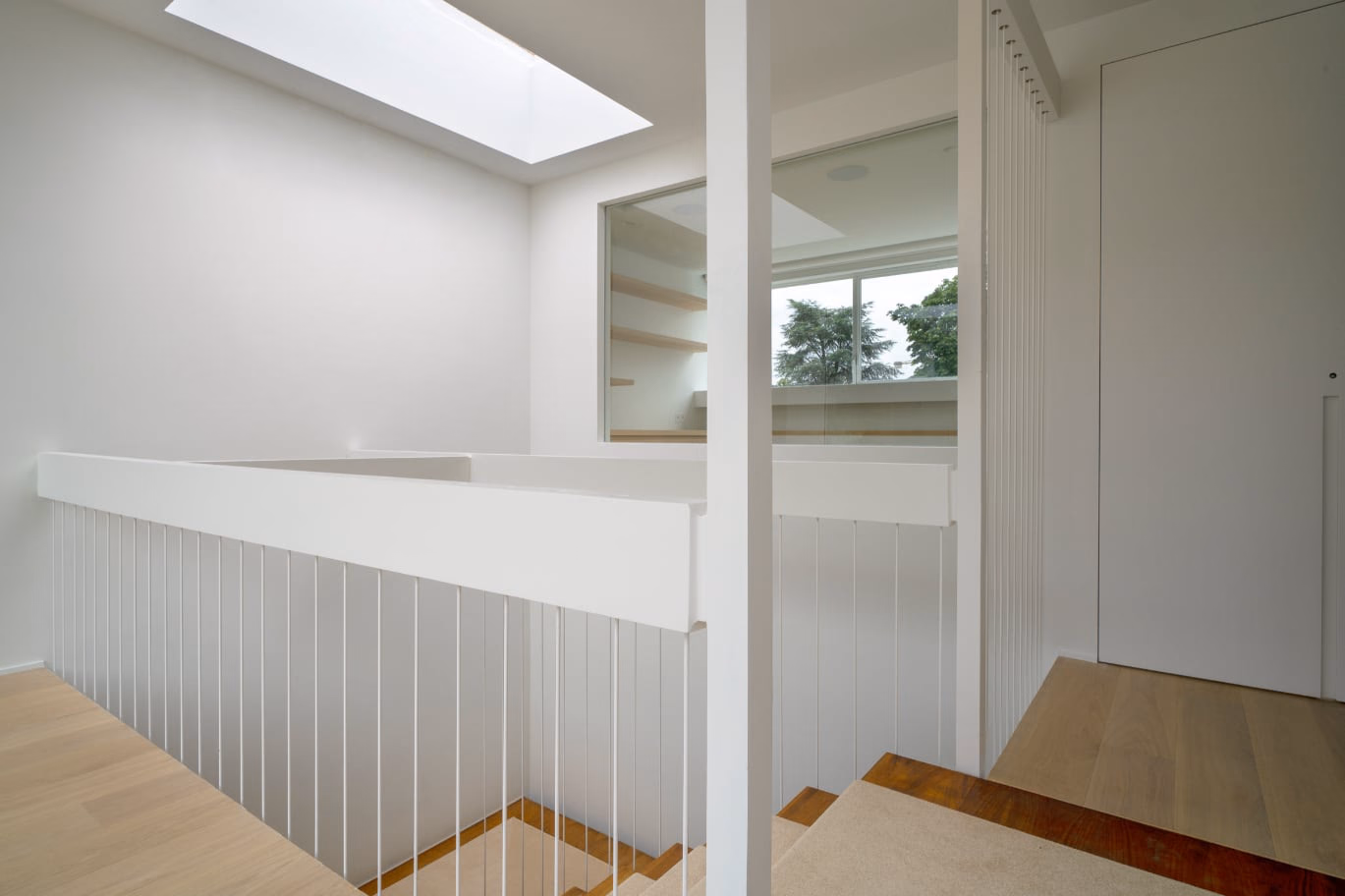 A staircase with a white balustrade and a window
