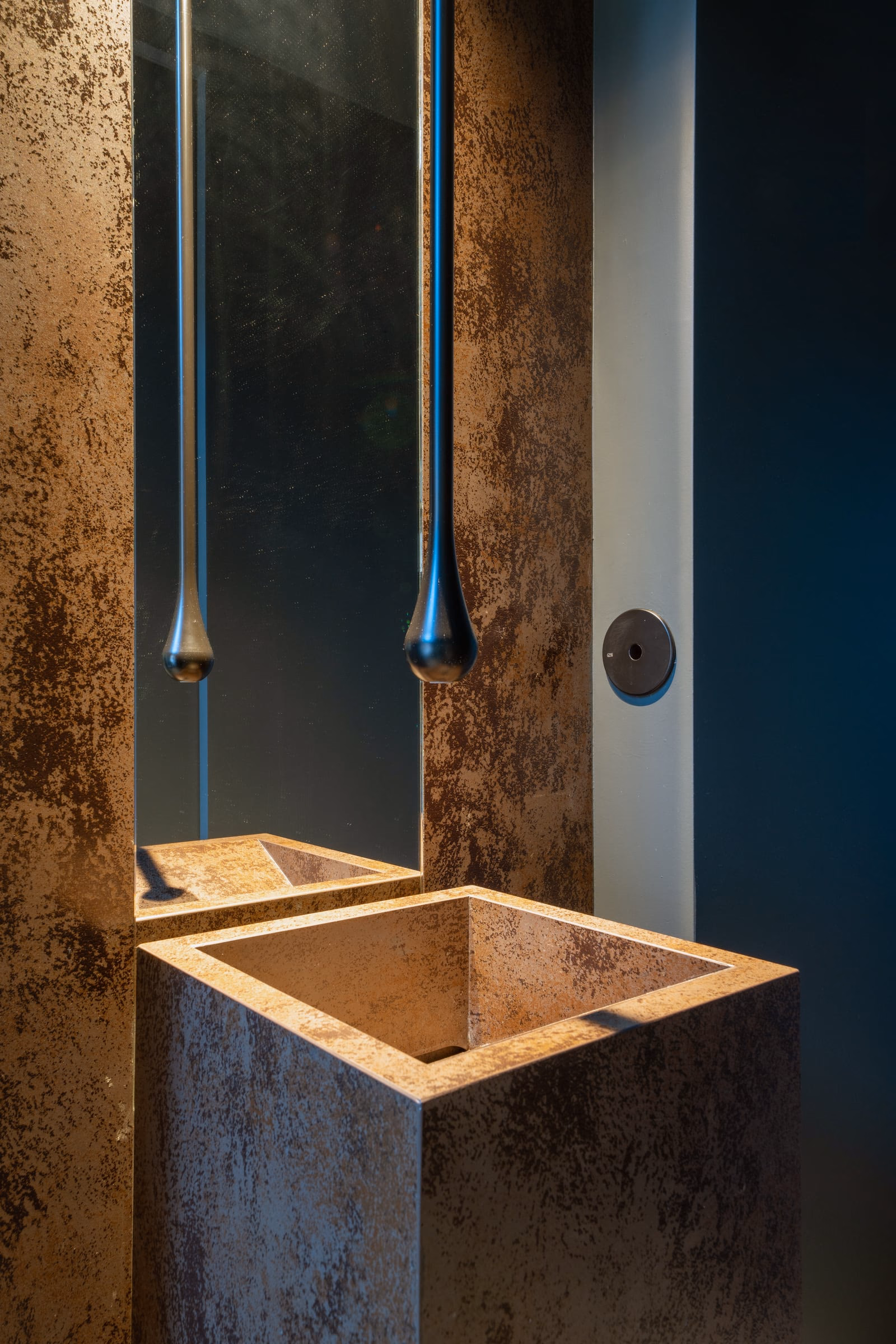 A bathroom with a square washbasin and a mirror