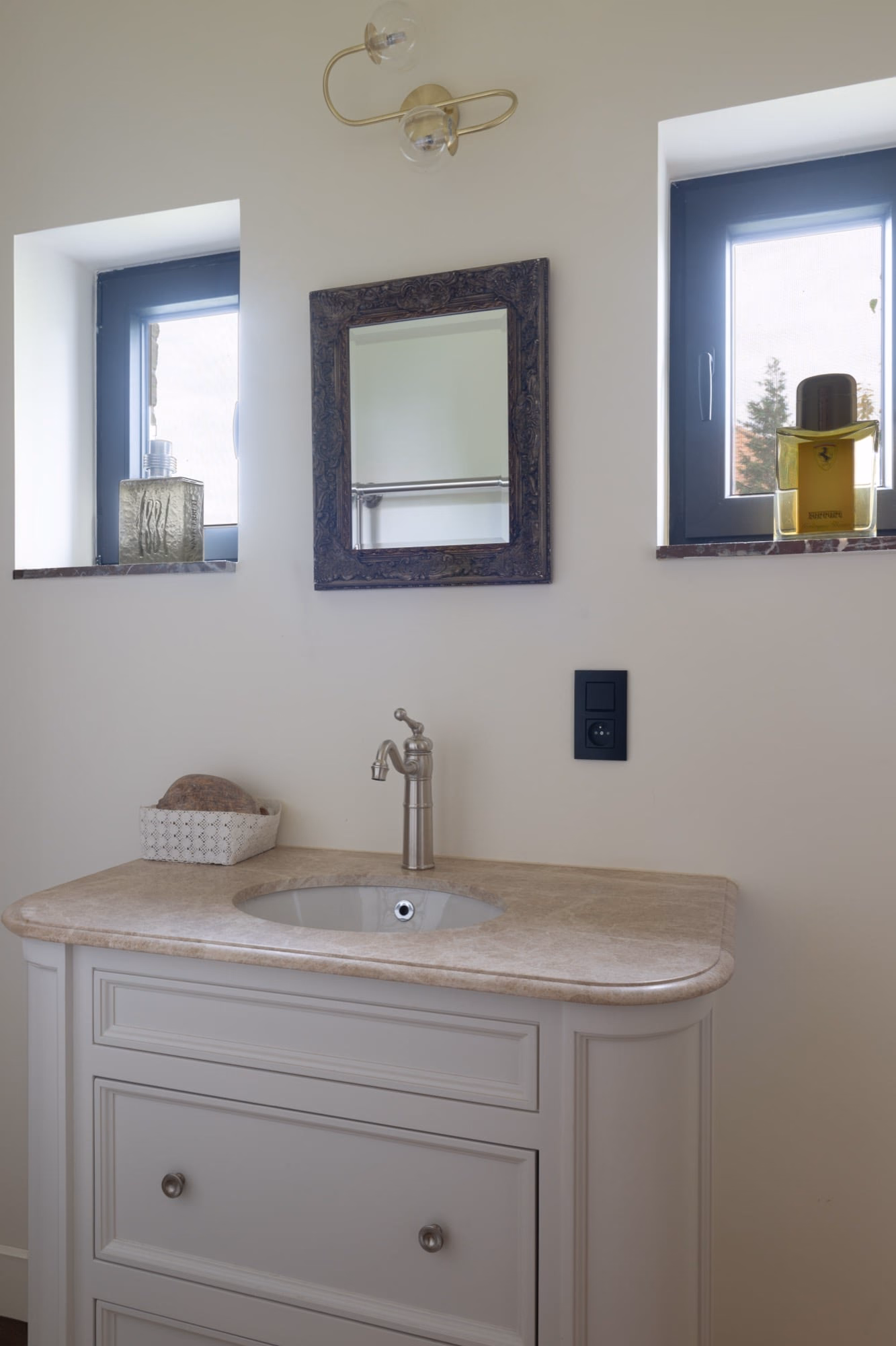 A bathroom vanity with a washbasin and a mirror