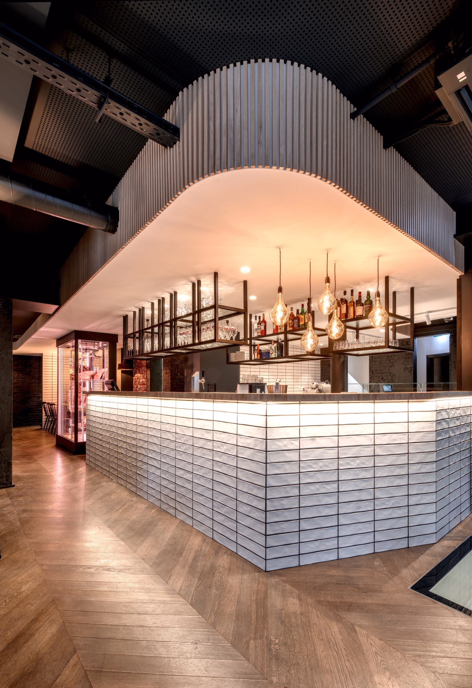 A bar with bottles and glasses hanging from the ceiling