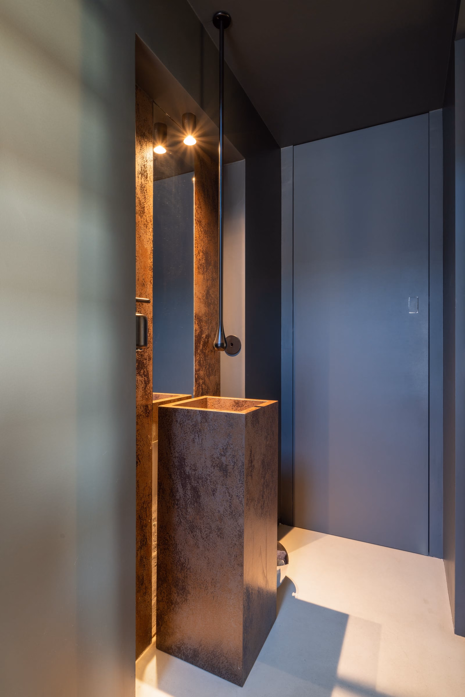 A bathroom with a copper washbasin and a mirror