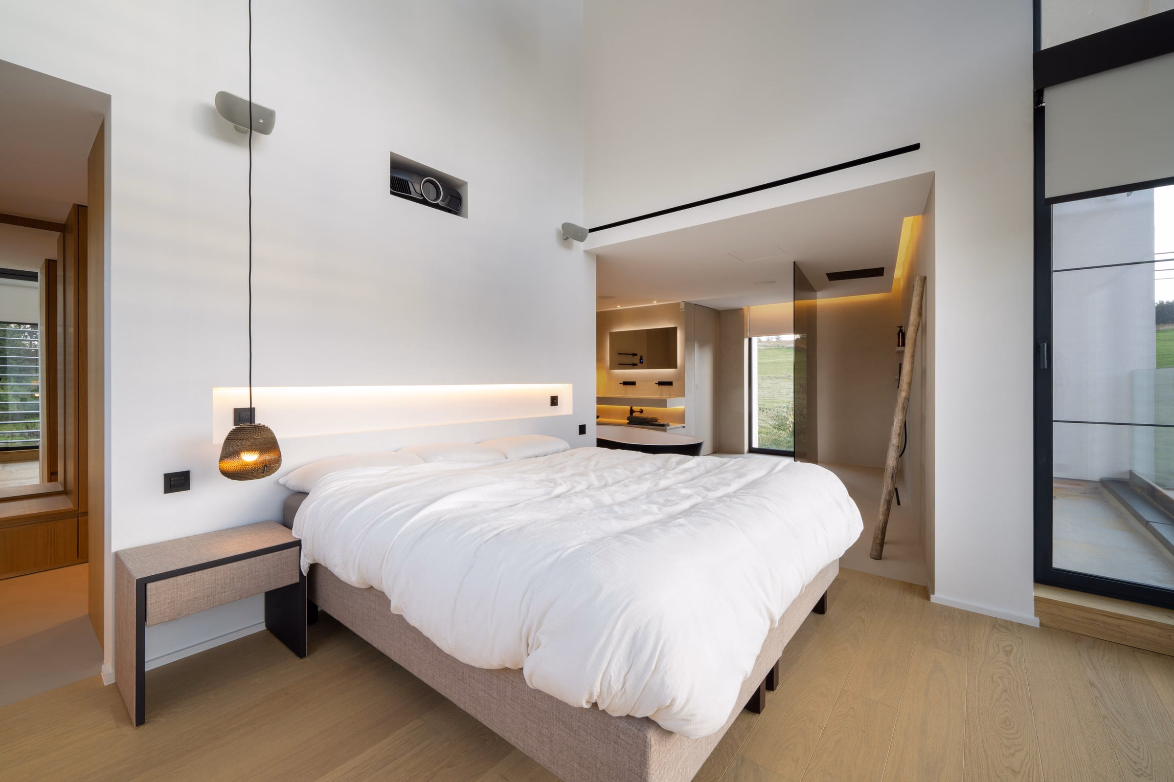 A bedroom with a large bed and a projector
