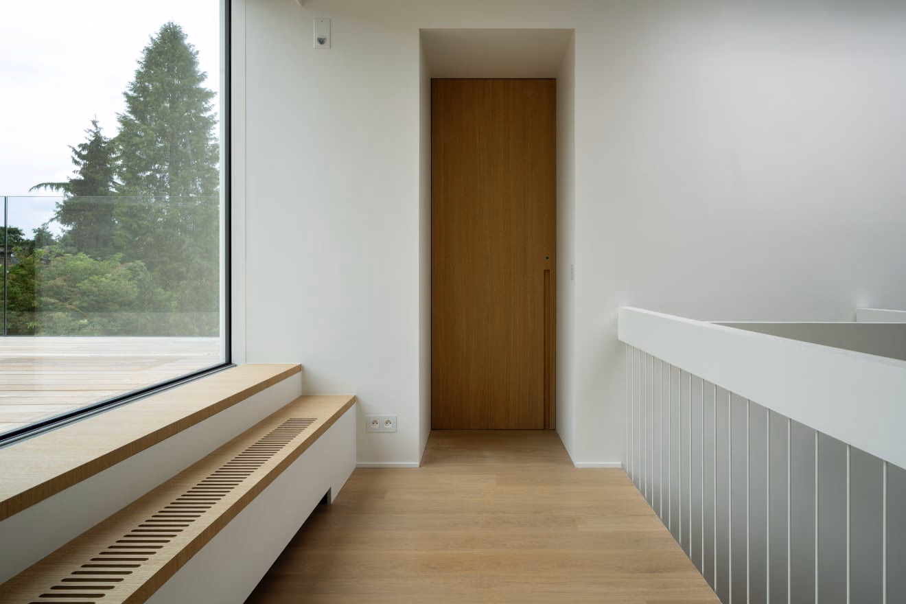 A hallway with a wooden door and a window