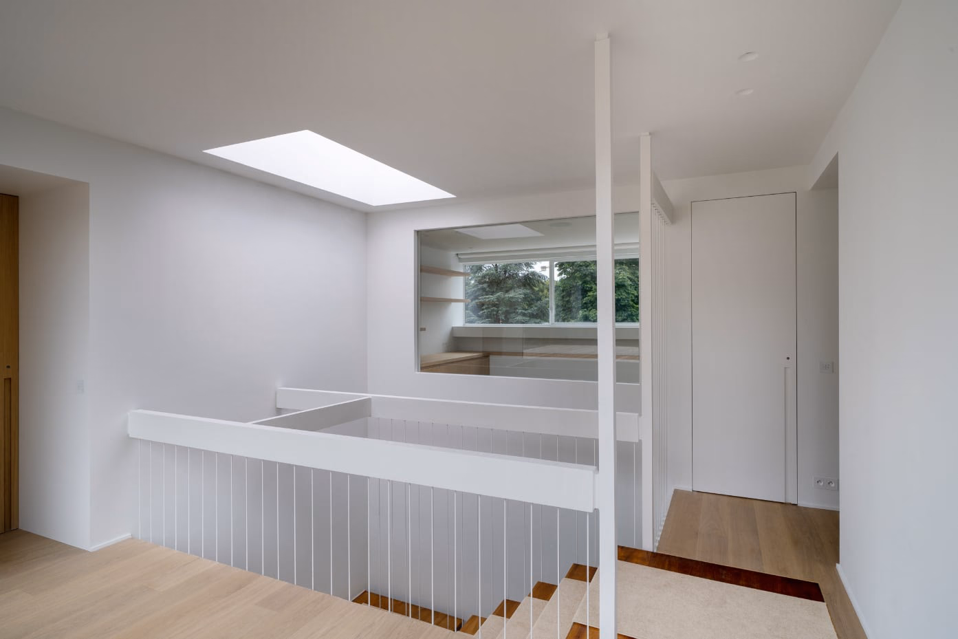 A staircase with a white balustrade and a window