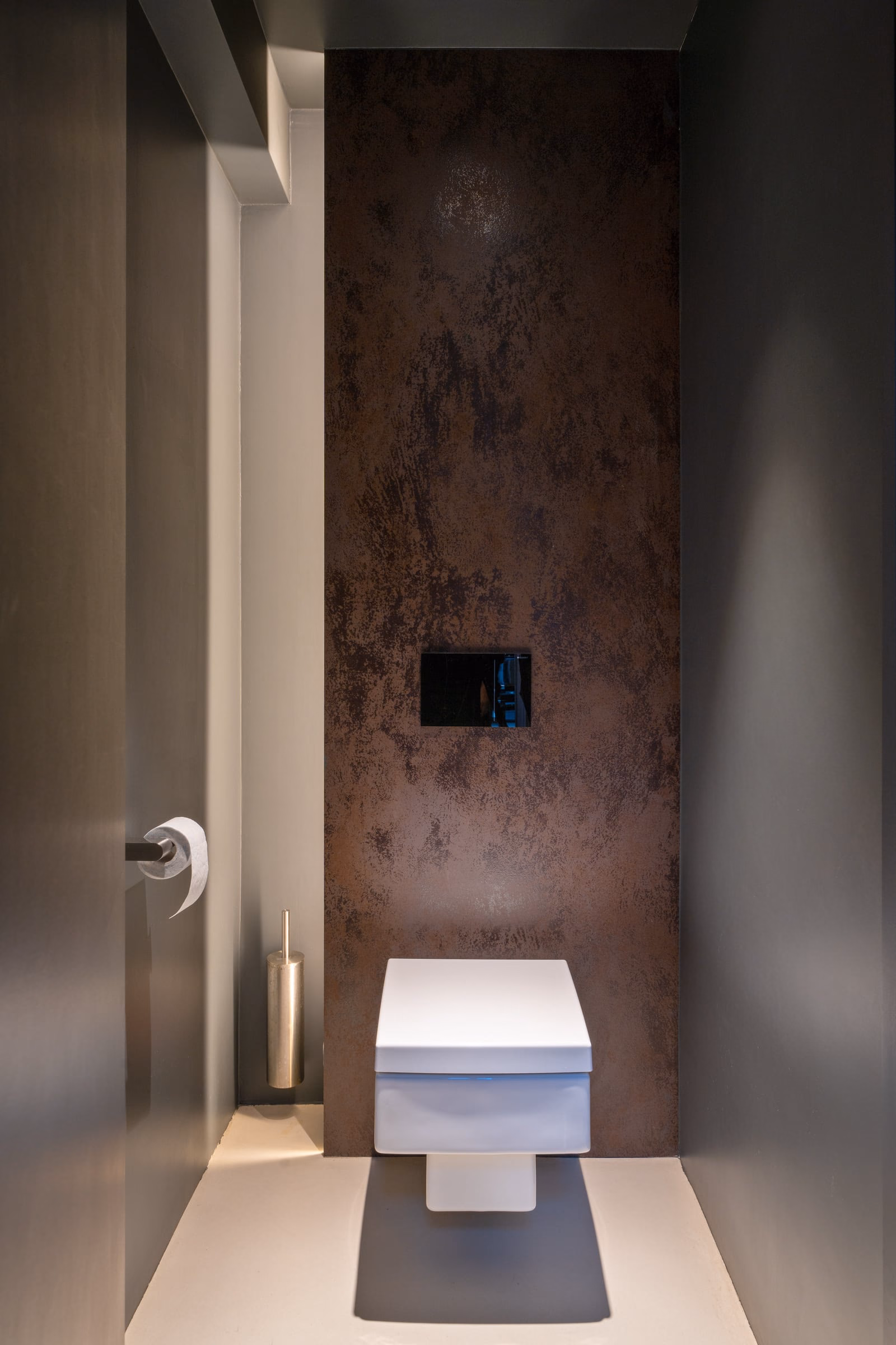 A bathroom with a brown wall and a white toilet