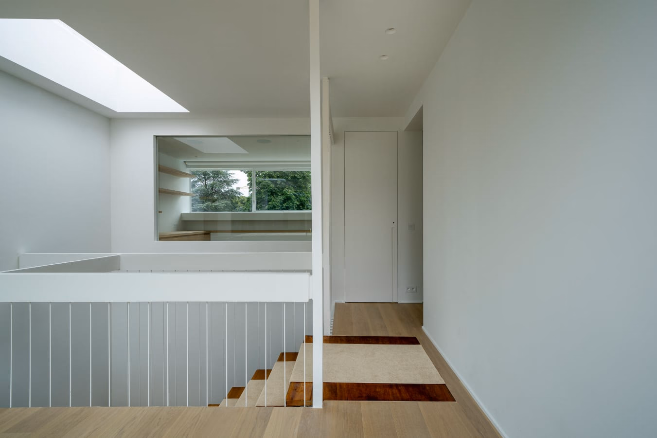 A hallway with a staircase and a window