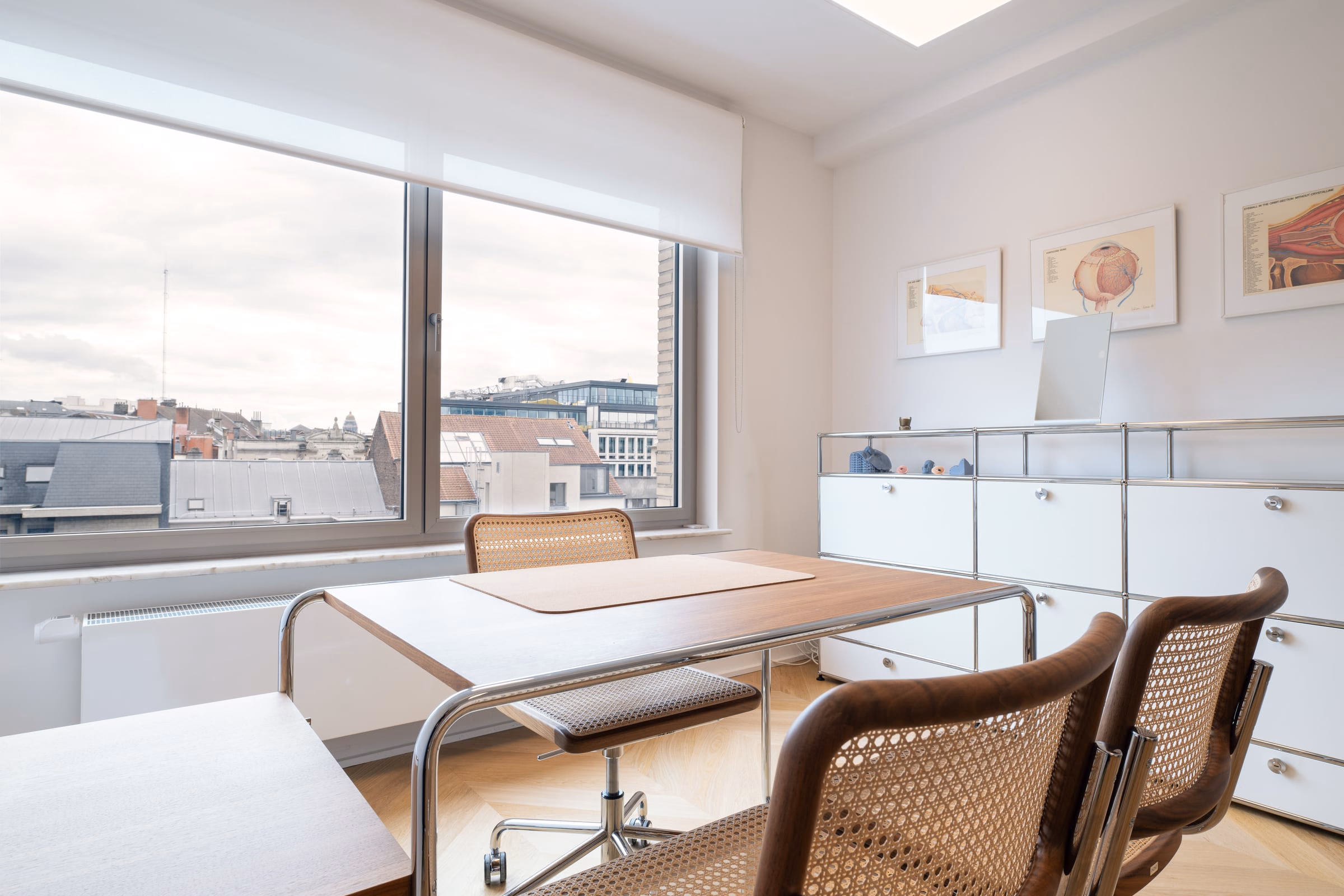 A wicker chair at a desk in front of a window