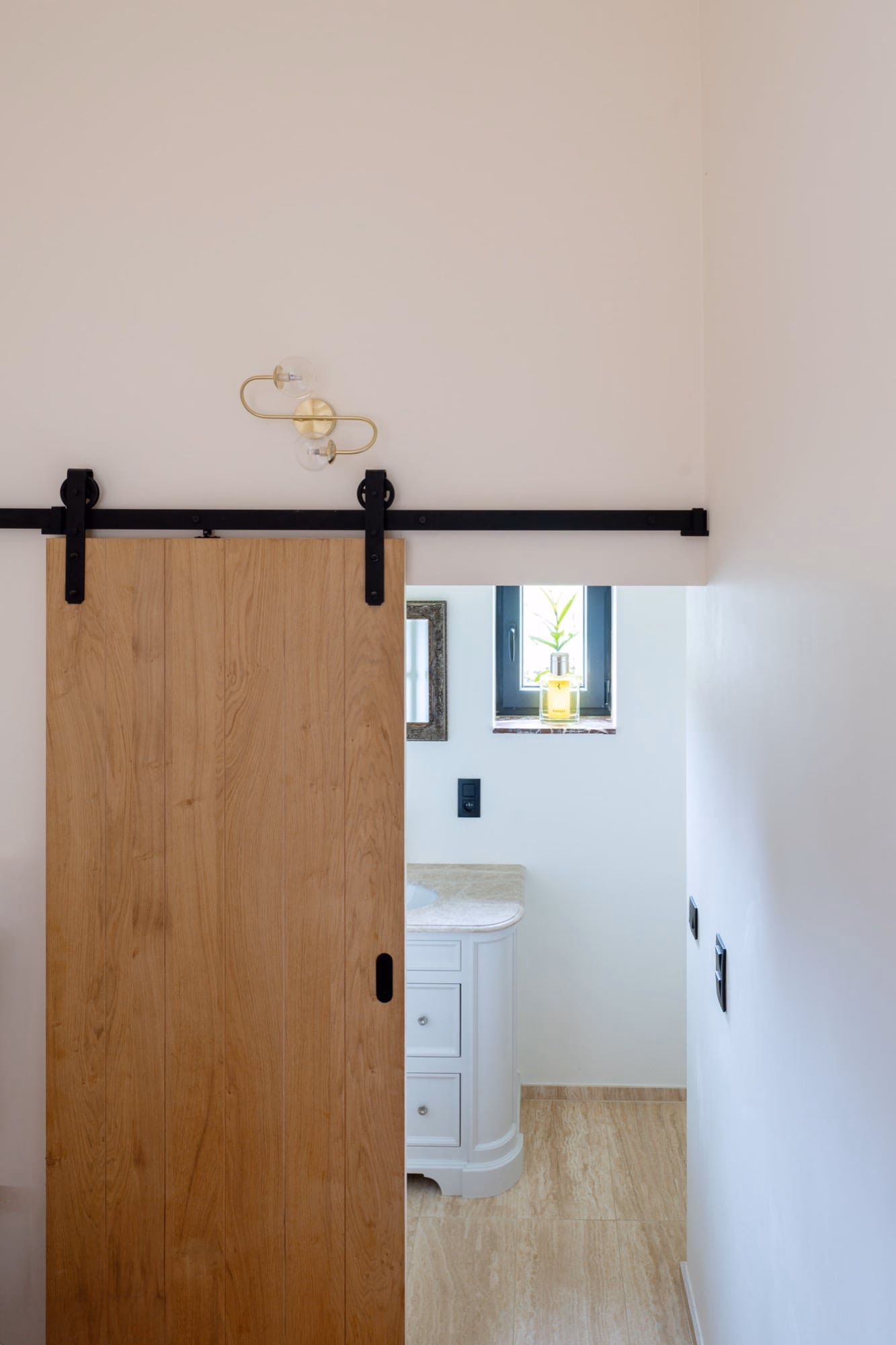 A bathroom with a sliding barn door and a window