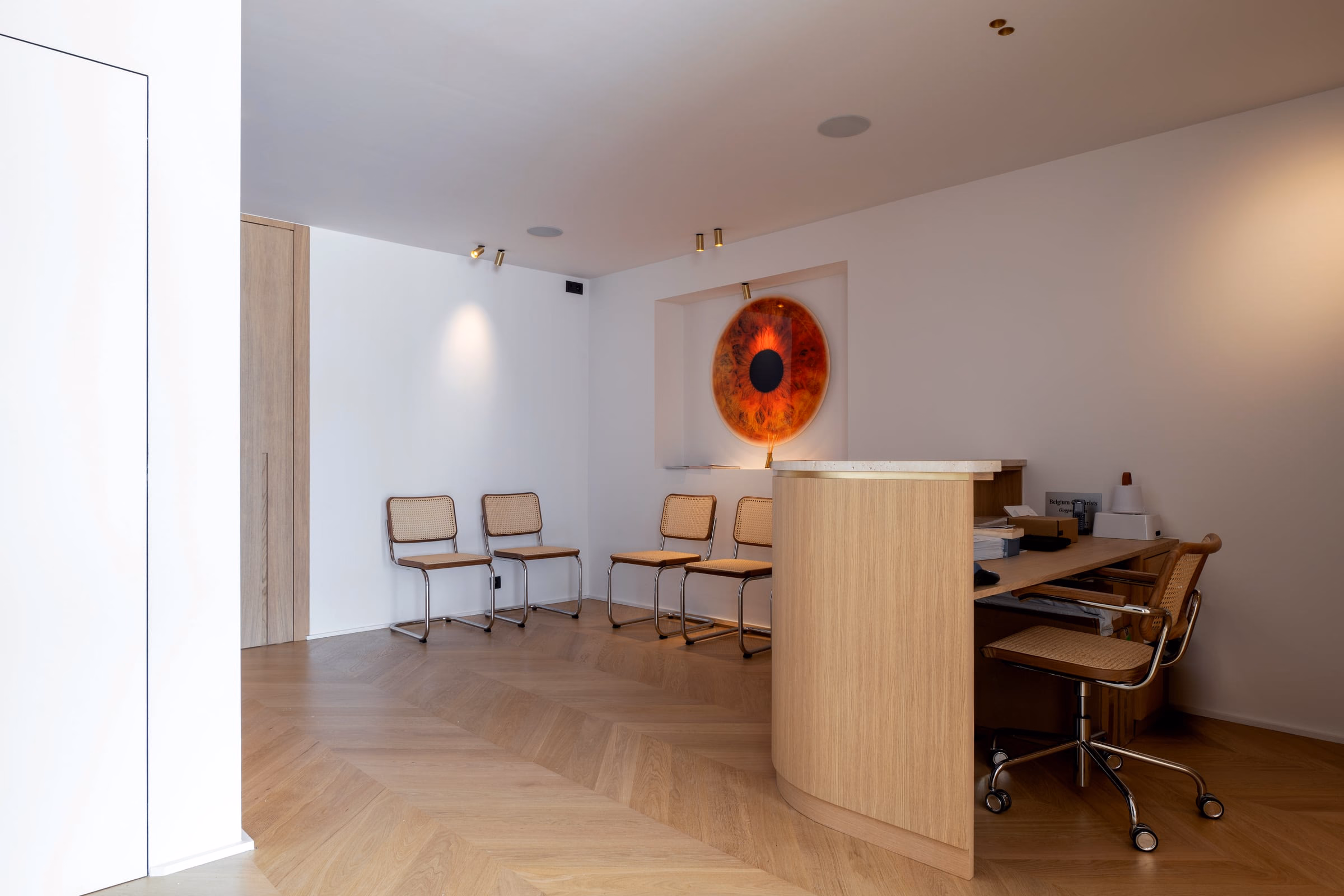 A waiting room with chairs and a painting on the wall