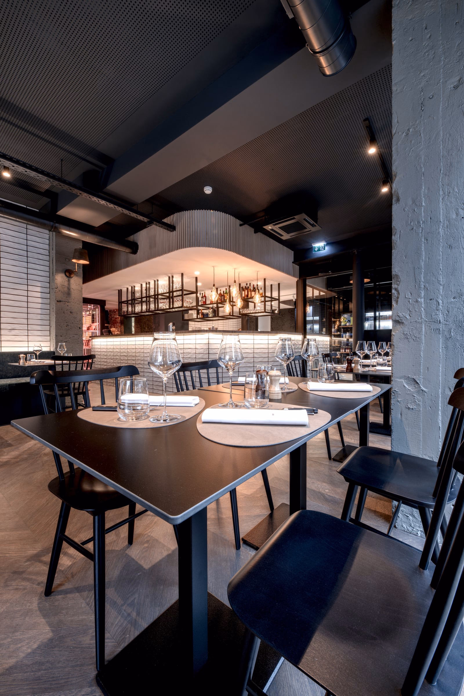 A restaurant with tables, chairs and glasses
