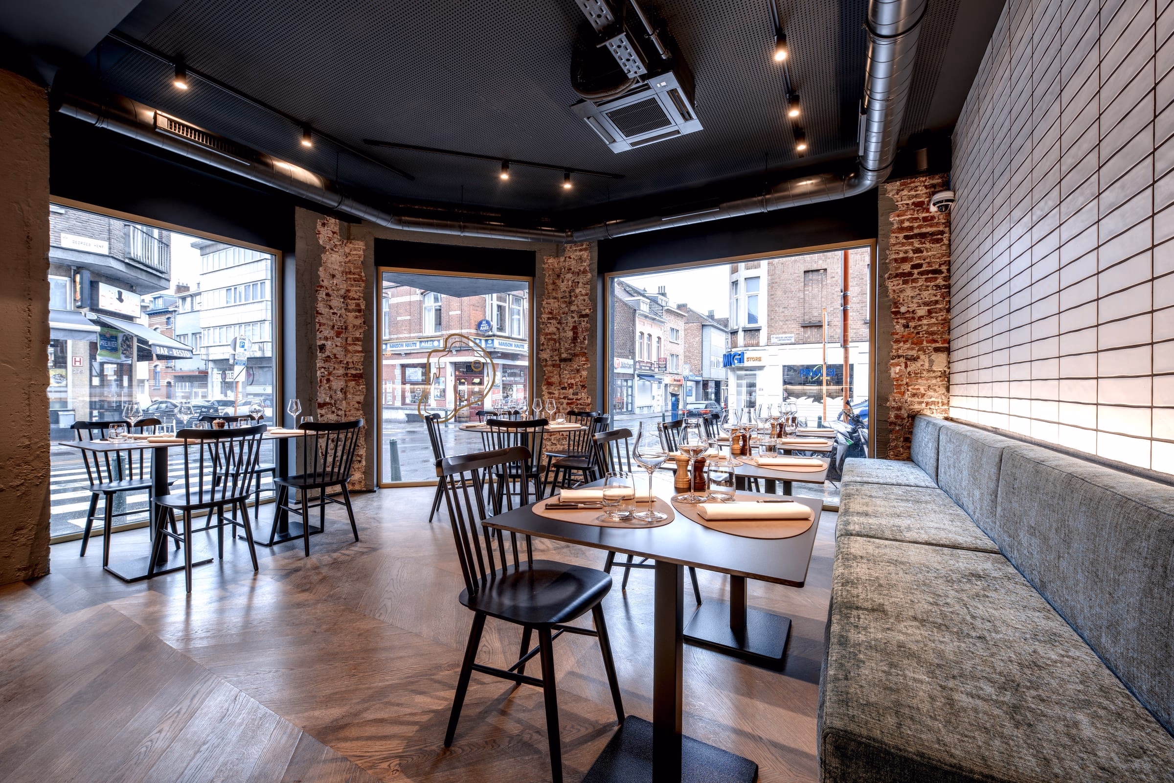A restaurant with tables, chairs and a brick wall