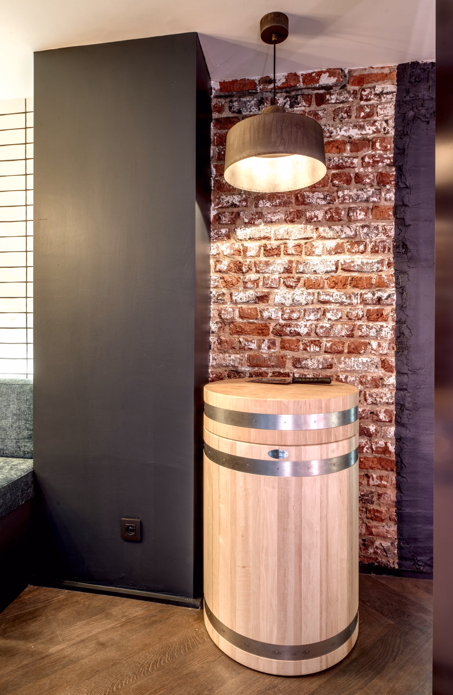 A wooden barrel in front of a brick wall