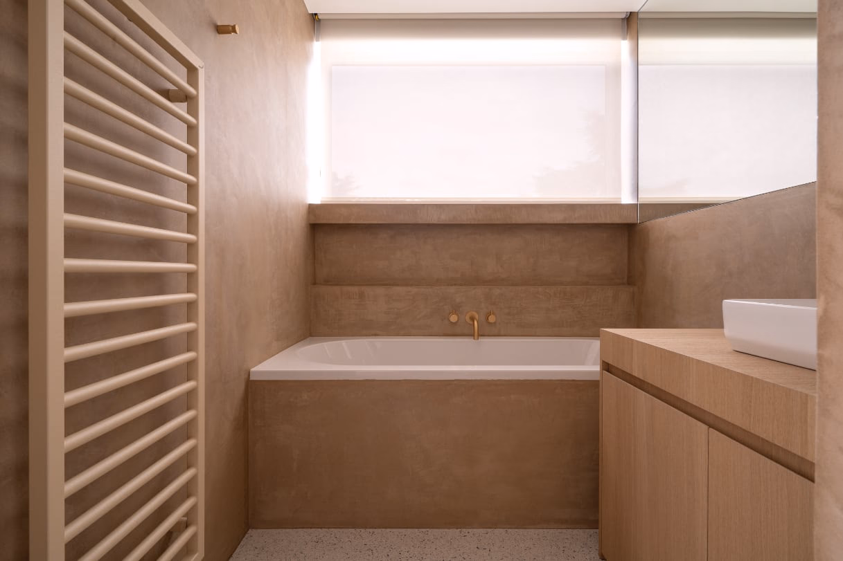 A bathroom with a bathtub and a towel rail
