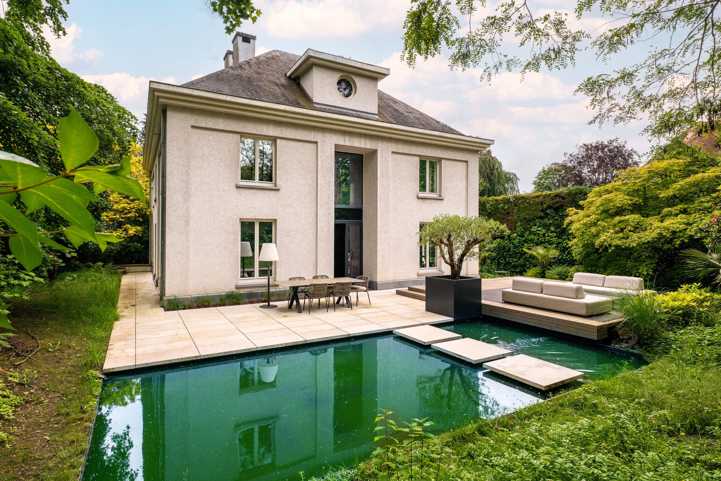 A large white house with a swimming pool in front