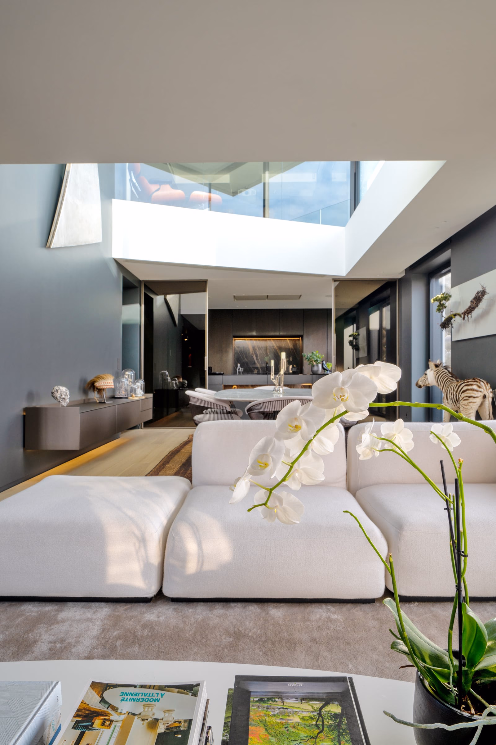 A living room with a white sofa and white flowers