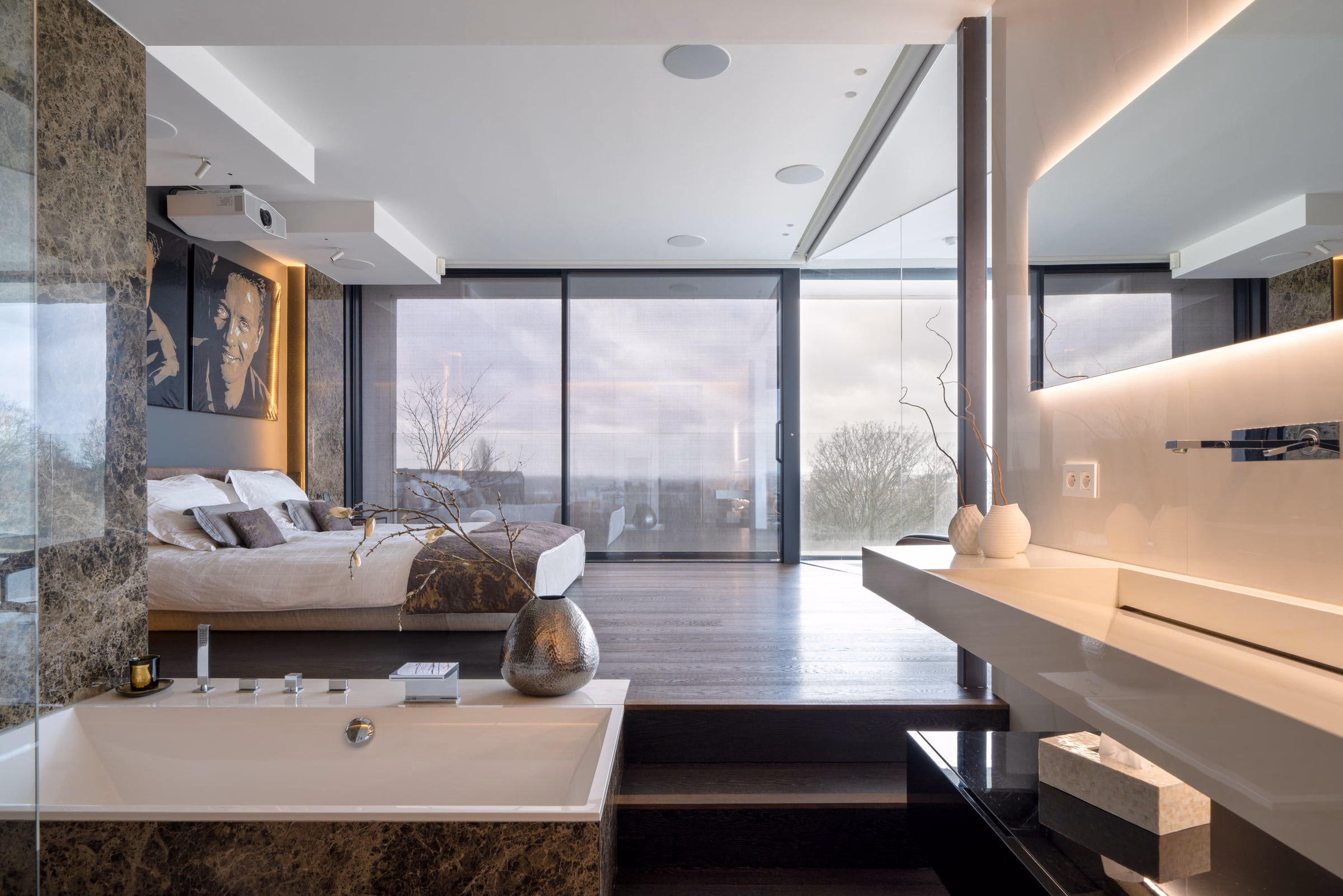 A bathtub beside the bed in an open bedroom