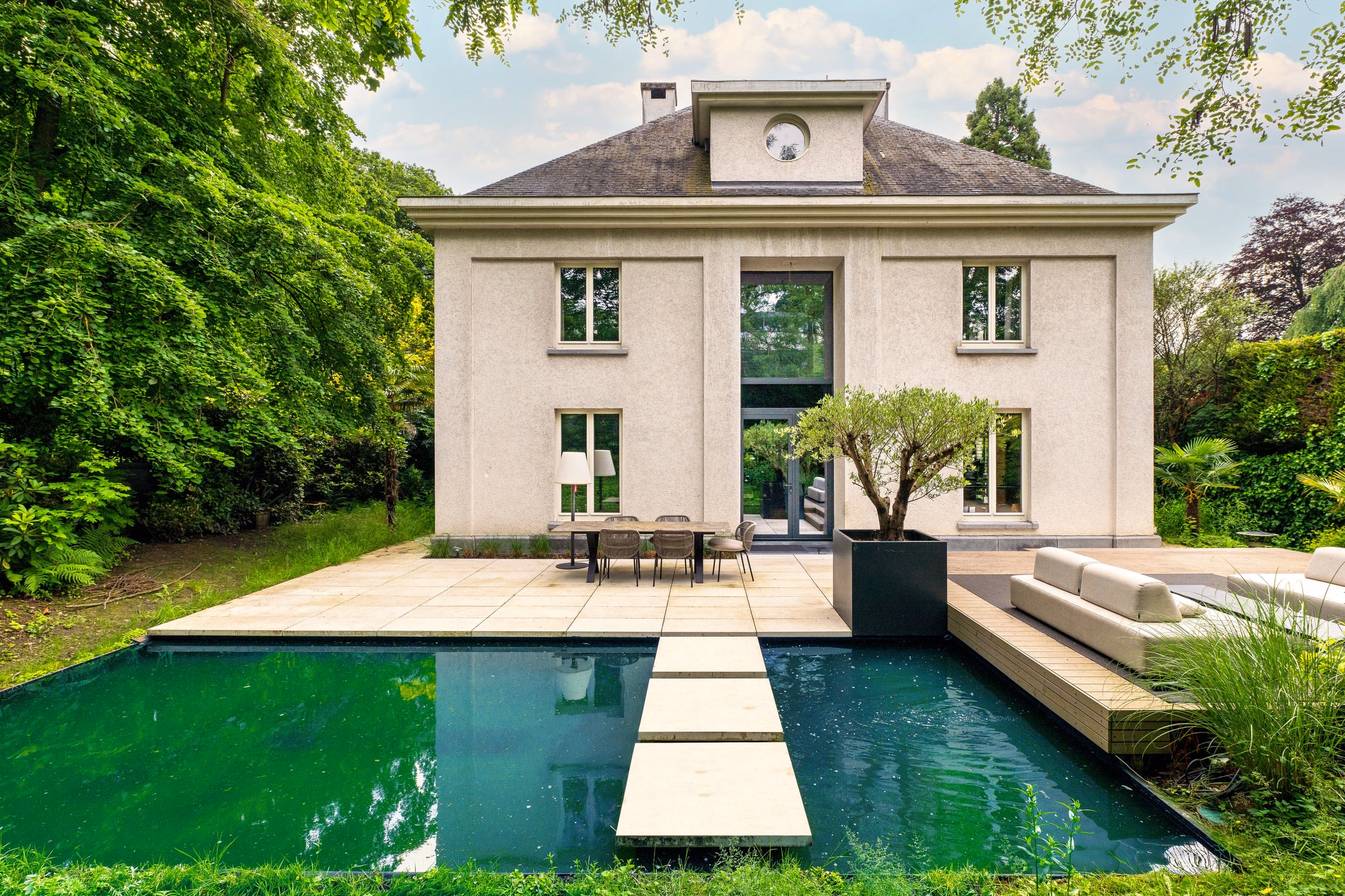 A large house with a swimming pool in front