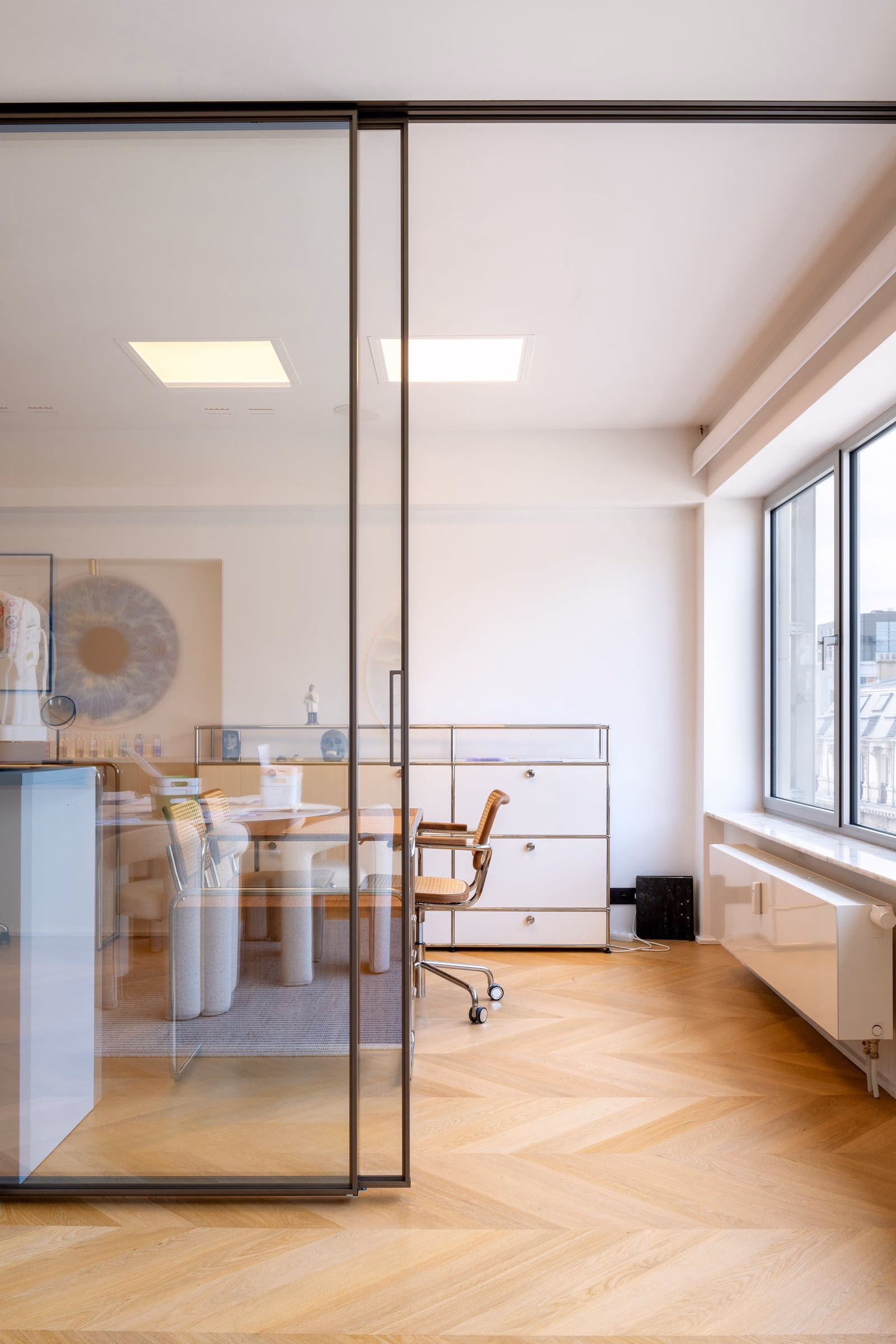 A room with a table and chairs behind a glass door