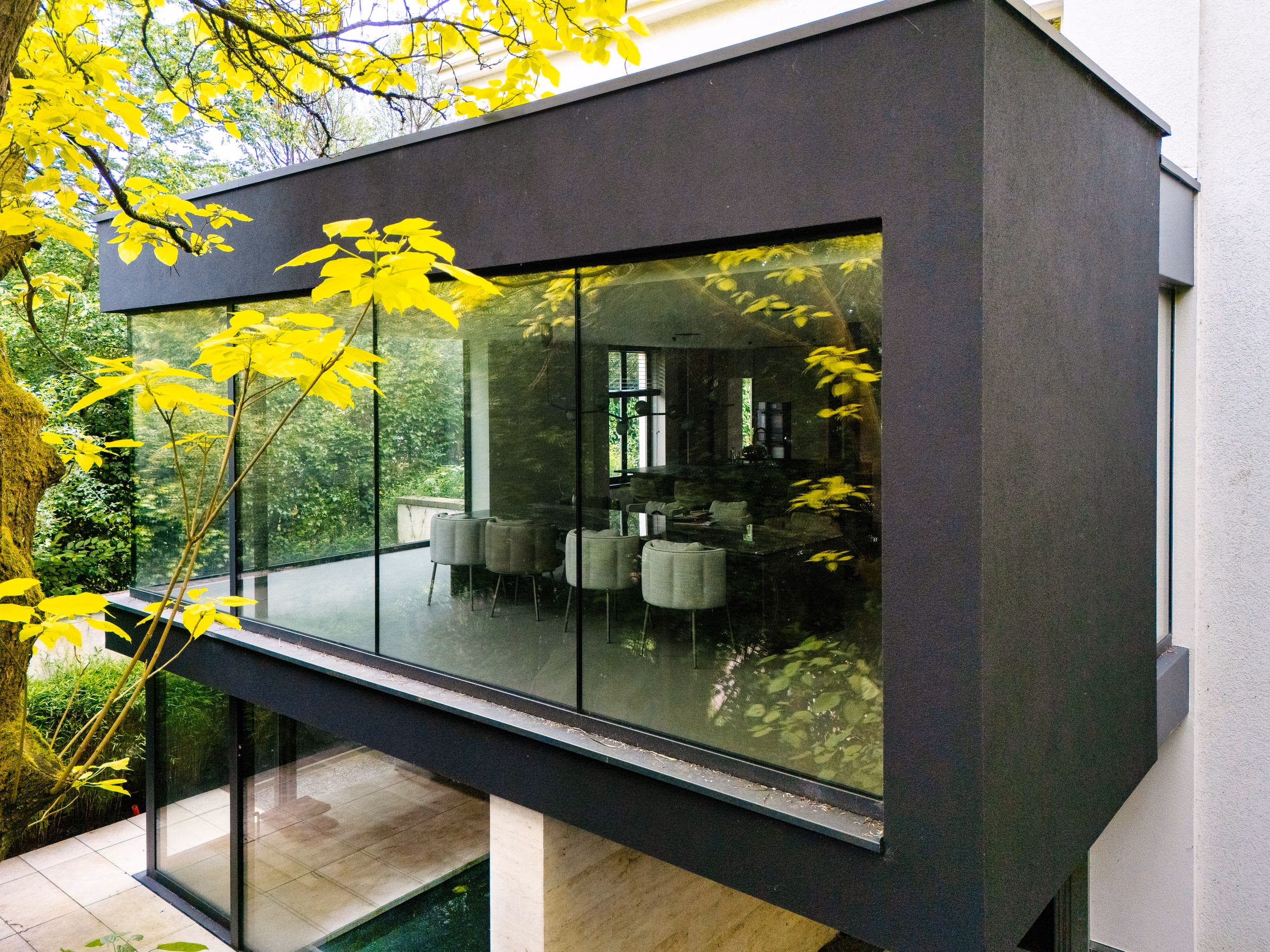 A dining room with a table and chairs before a large window