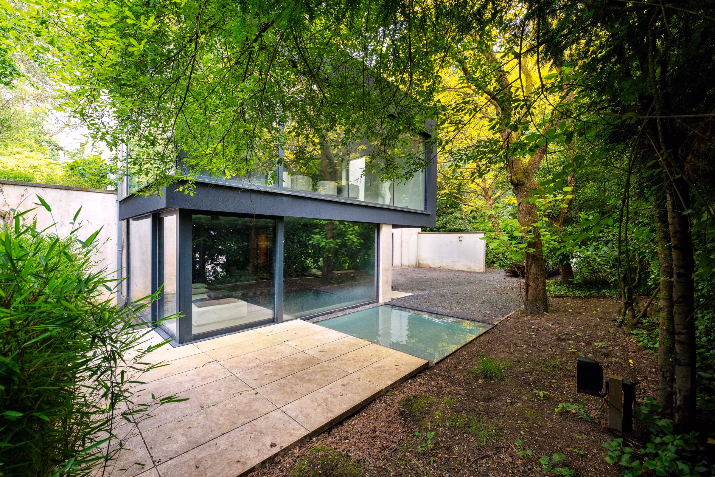 A house of tall windows set among trees