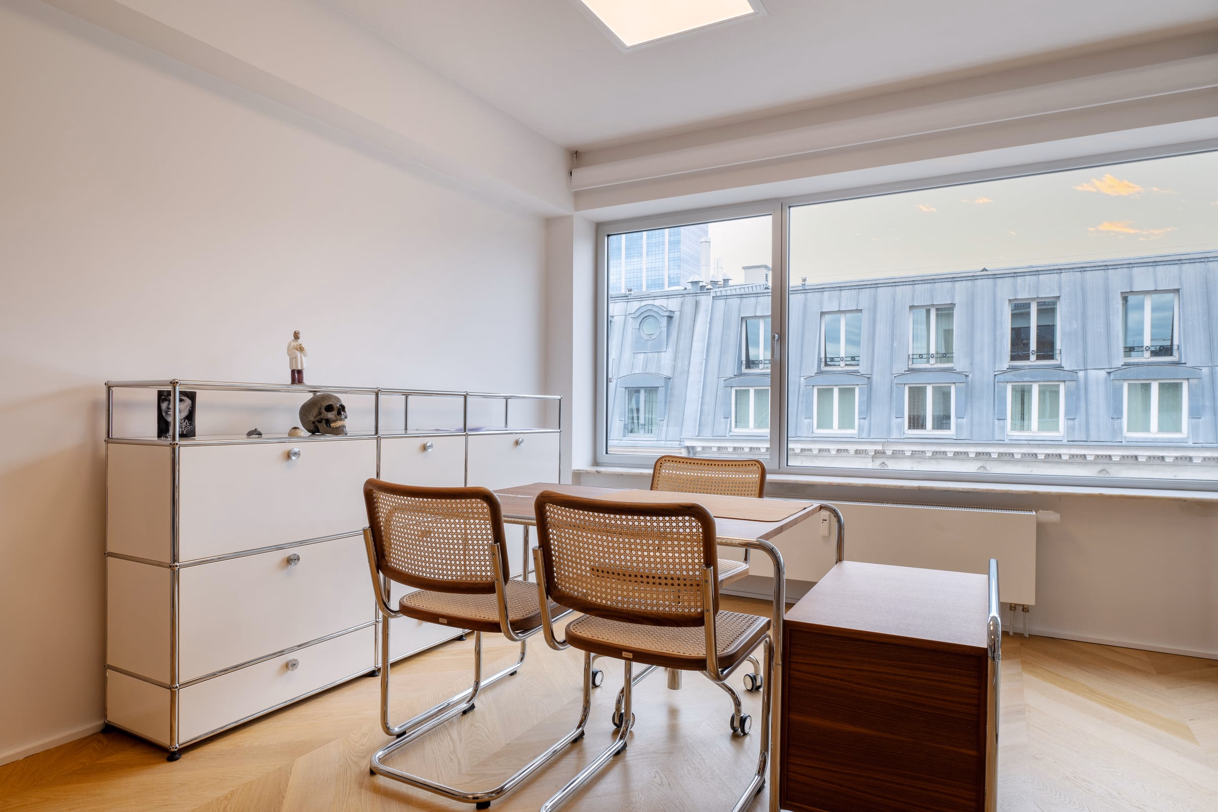 A room with a table, chairs and a window